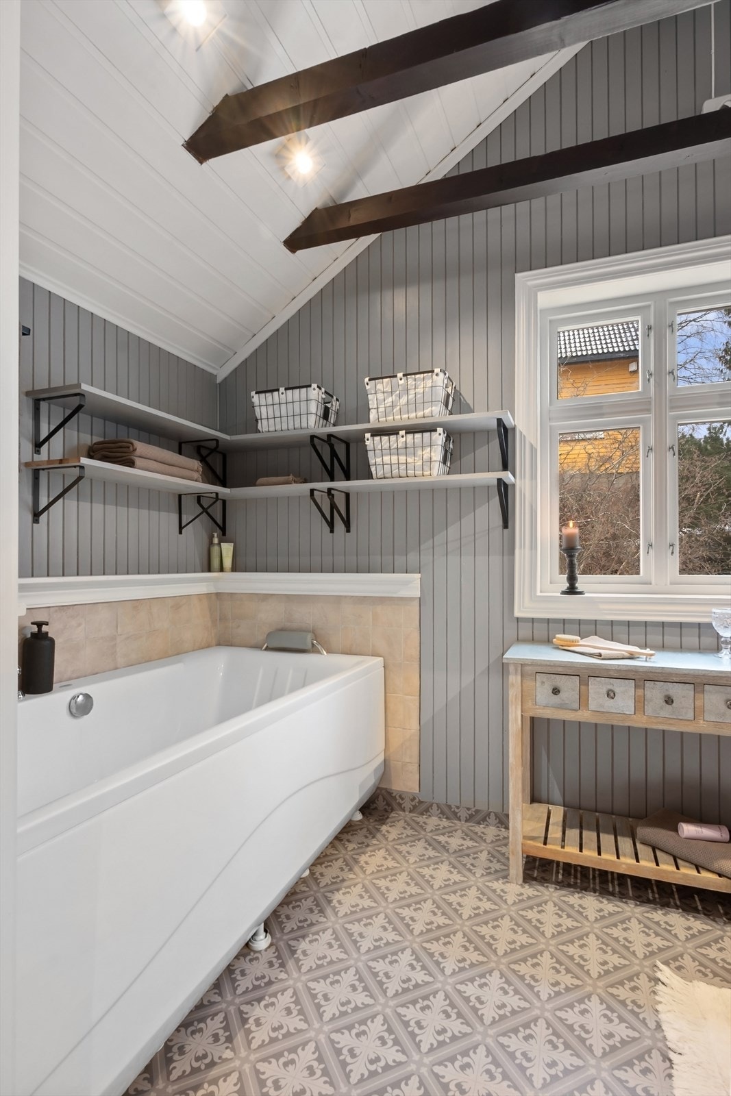 Badet har god takhøyde med skråtak og synlige, mørke takbjelker. Galleribilde