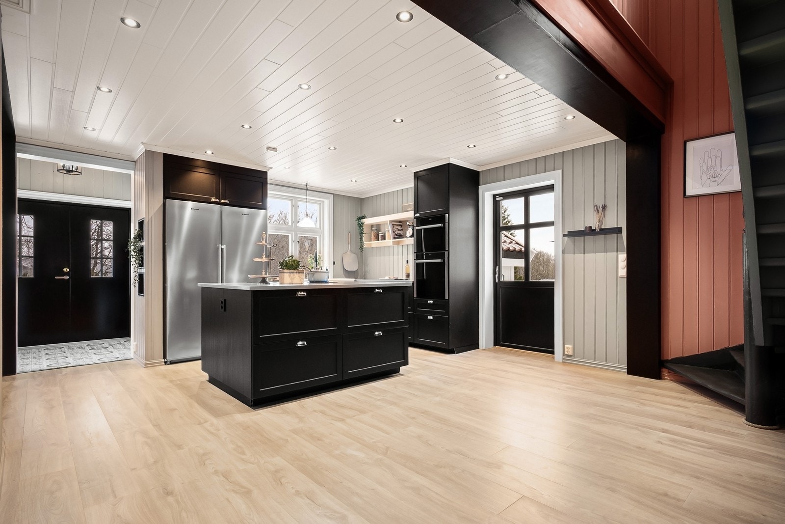 Boligens hoveddel byr på en romslig og sosial stue- og kjøkkenløsning. Det åpne rommet nås naturlig fra begge inngangspartier, og den vestvendte verandaen på 55 kvm er lett tilgjengelig via verandadør fra kjøkkenet. Galleribilde