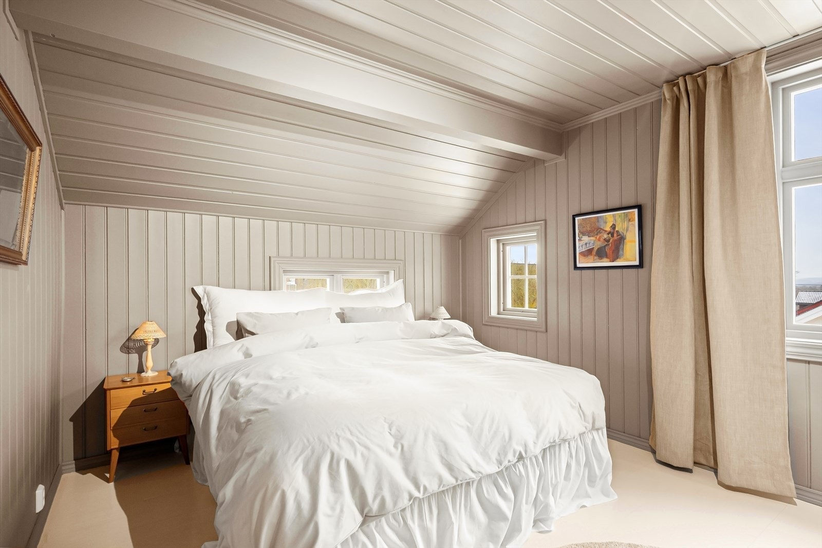 Hovedsoverommet fremstår som et innbydende og romslig soverom med malte panelvegger og god plass til dobbeltseng og oppbevaring. Galleribilde