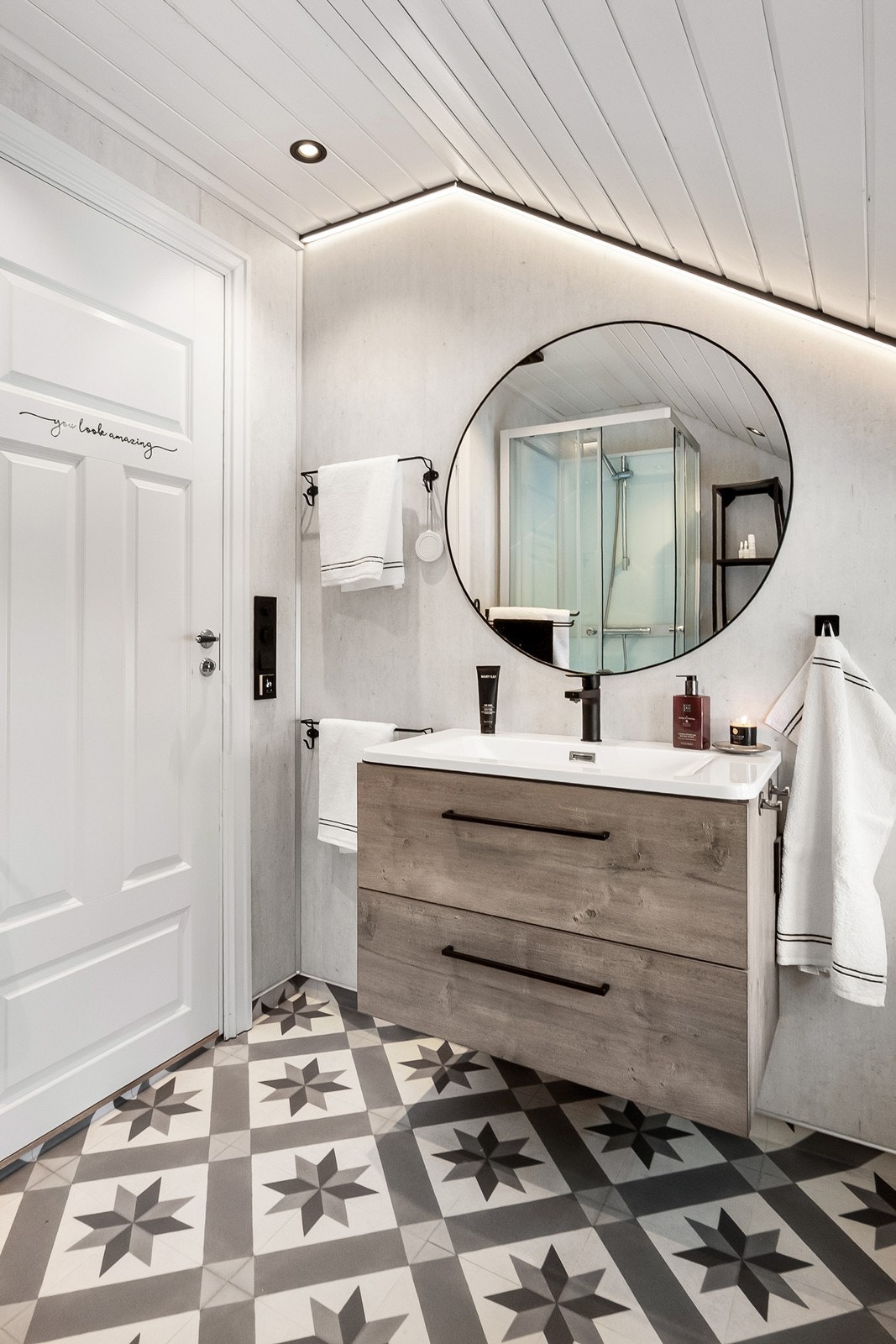 Badet har varme i gulv og vinylbelegg med oppbrett og sveisede skjøter. Dekorativt gulvmønster, skrå himling med panel, innfelte downlights og lyslist langs taket gir behagelig belysning. Galleribilde