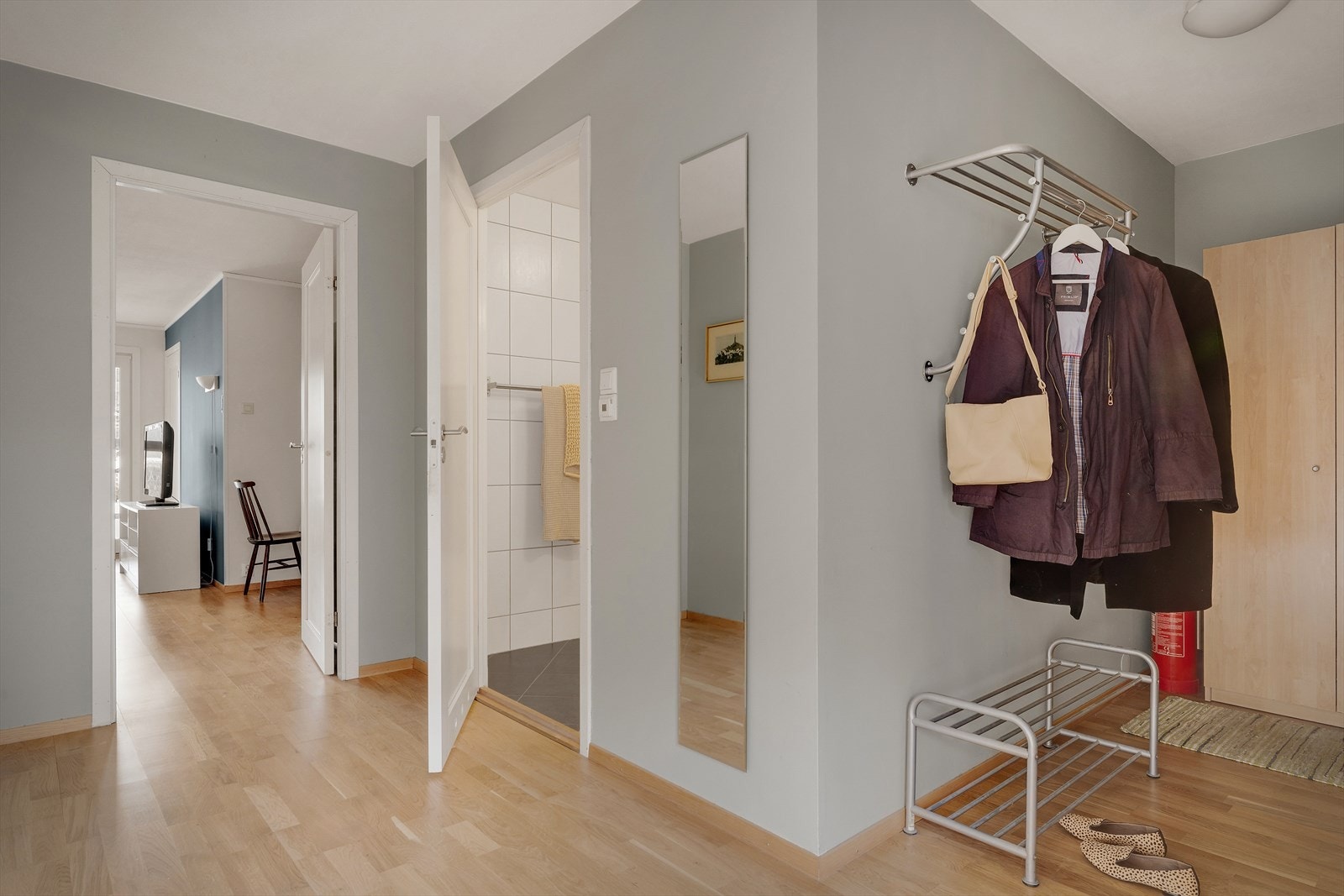 Lys og romslig entré på 9 m², med god garderobeplass og praktisk område for oppheng av klær og sko. Et innbydende førsteinntrykk som gir leiligheten en åpen og ryddig start Galleribilde
