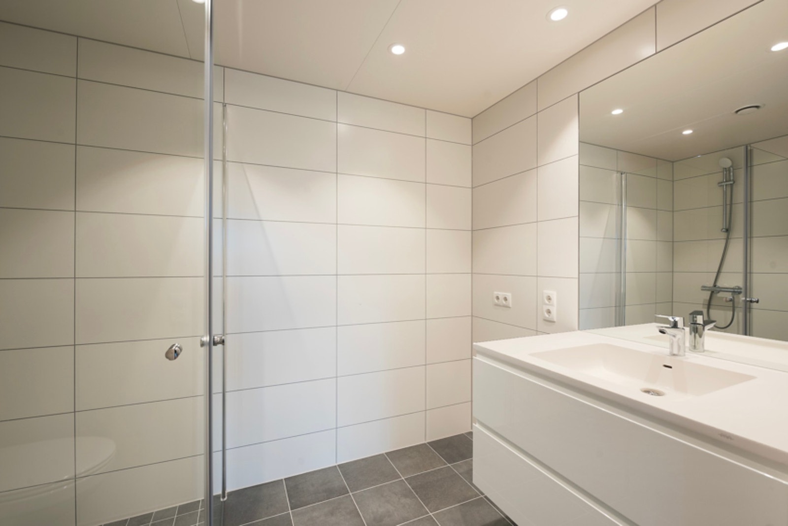 Lekkert bad med wc, servant og dusjhjørne samt opplegg for vaskemaskin og tørketrommel Galleribilde