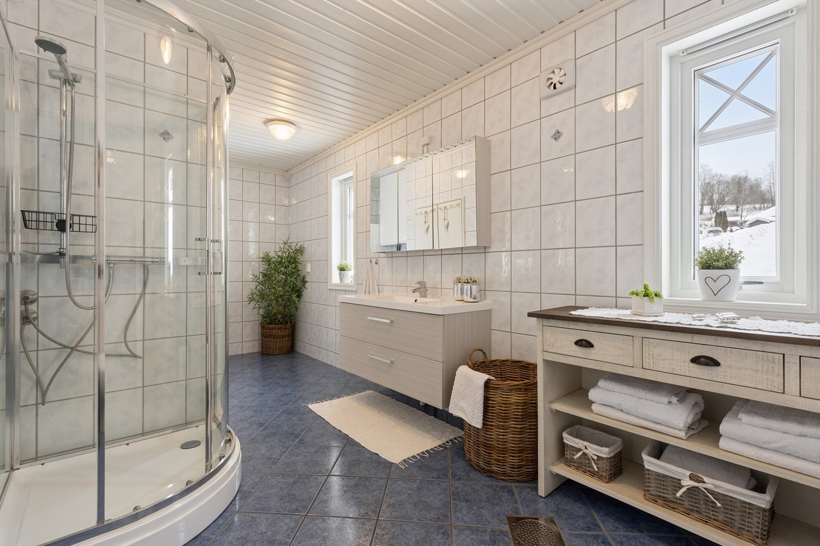 Romslig bad, som er fra 2001, har fliser på både vegger og gulv, med panel i taket. Det er installert elektriske varmekabler i gulvet. Galleribilde