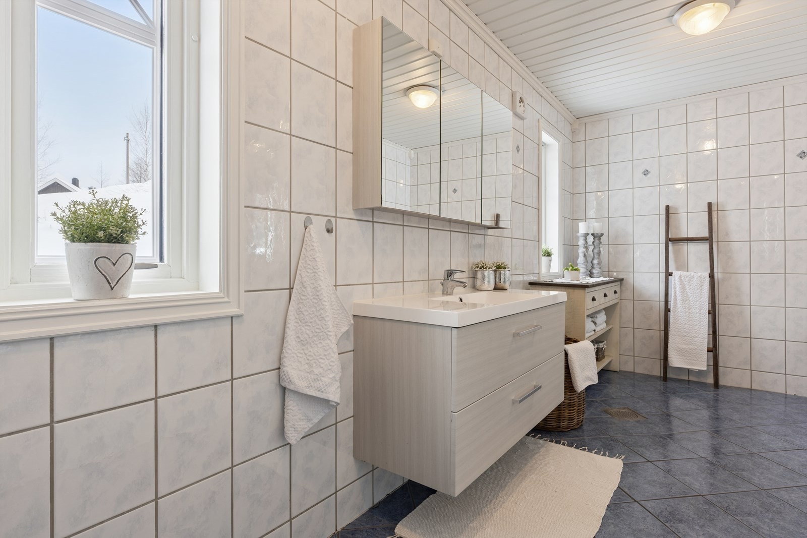 baderomsinnredning med heldekkende servant, praktisk speilskap, toalett og et dusjkabinett. Galleribilde