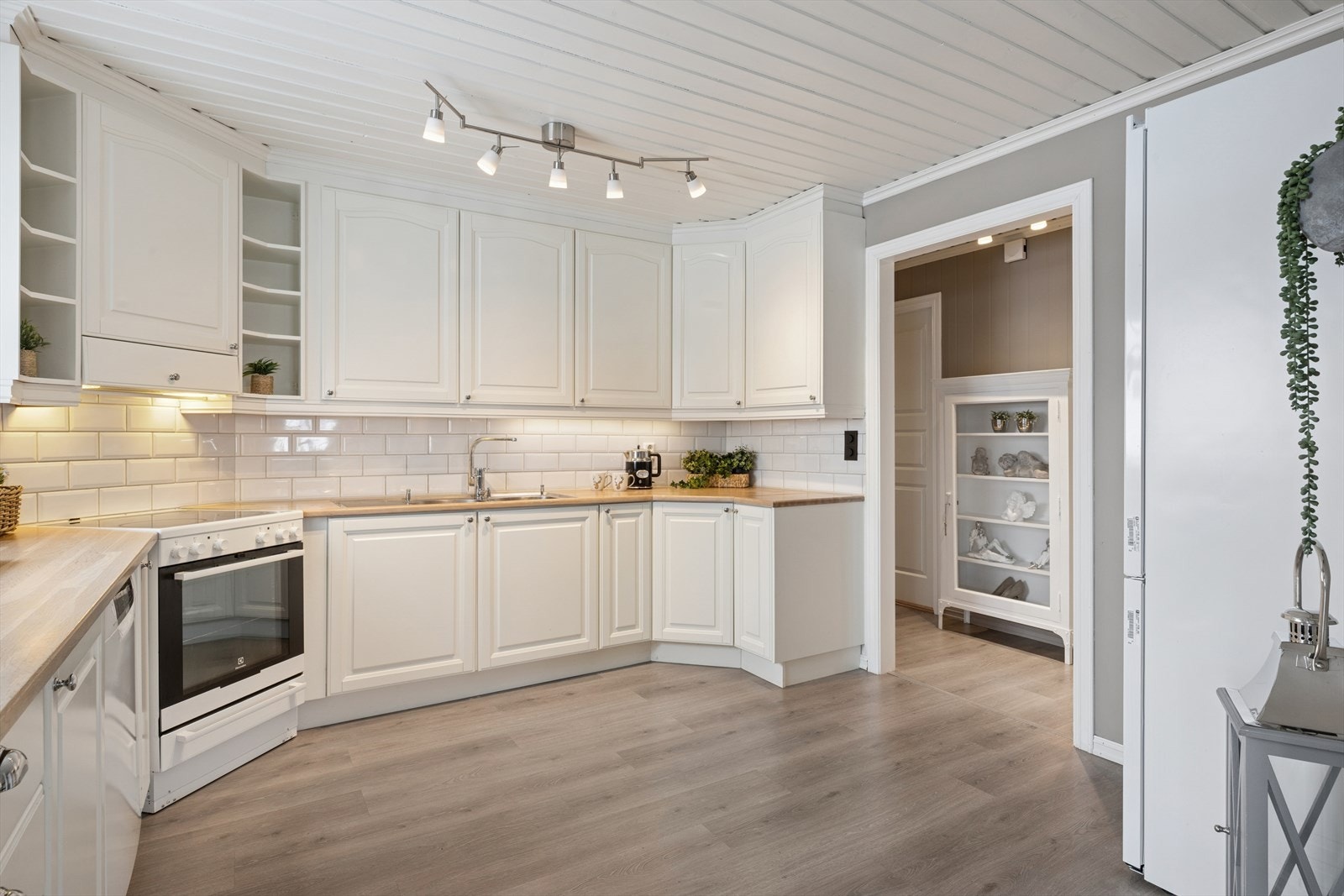 Innredningen er montert i en L-form, og er takhøy, noe som gir svært godt med skap- og benkeplass. Adkomst både fra gang og spisestue. Galleribilde