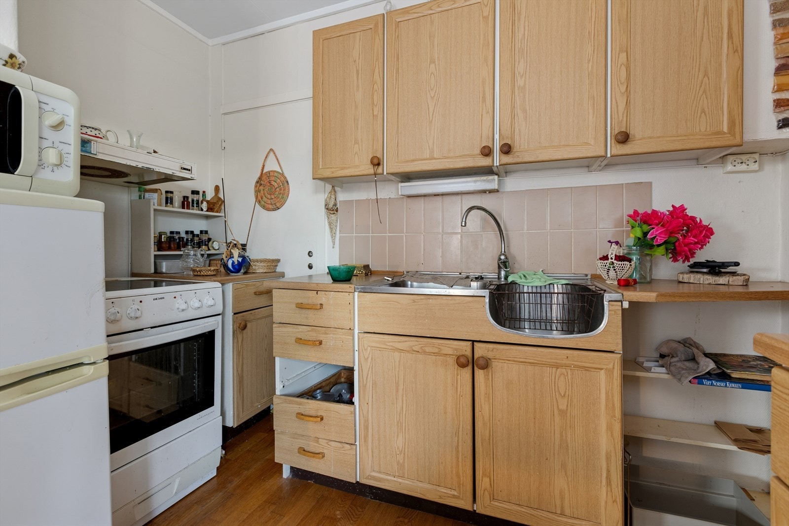 Kjøkkenet er av eldre stand med frittstående hvitevarer. Galleribilde