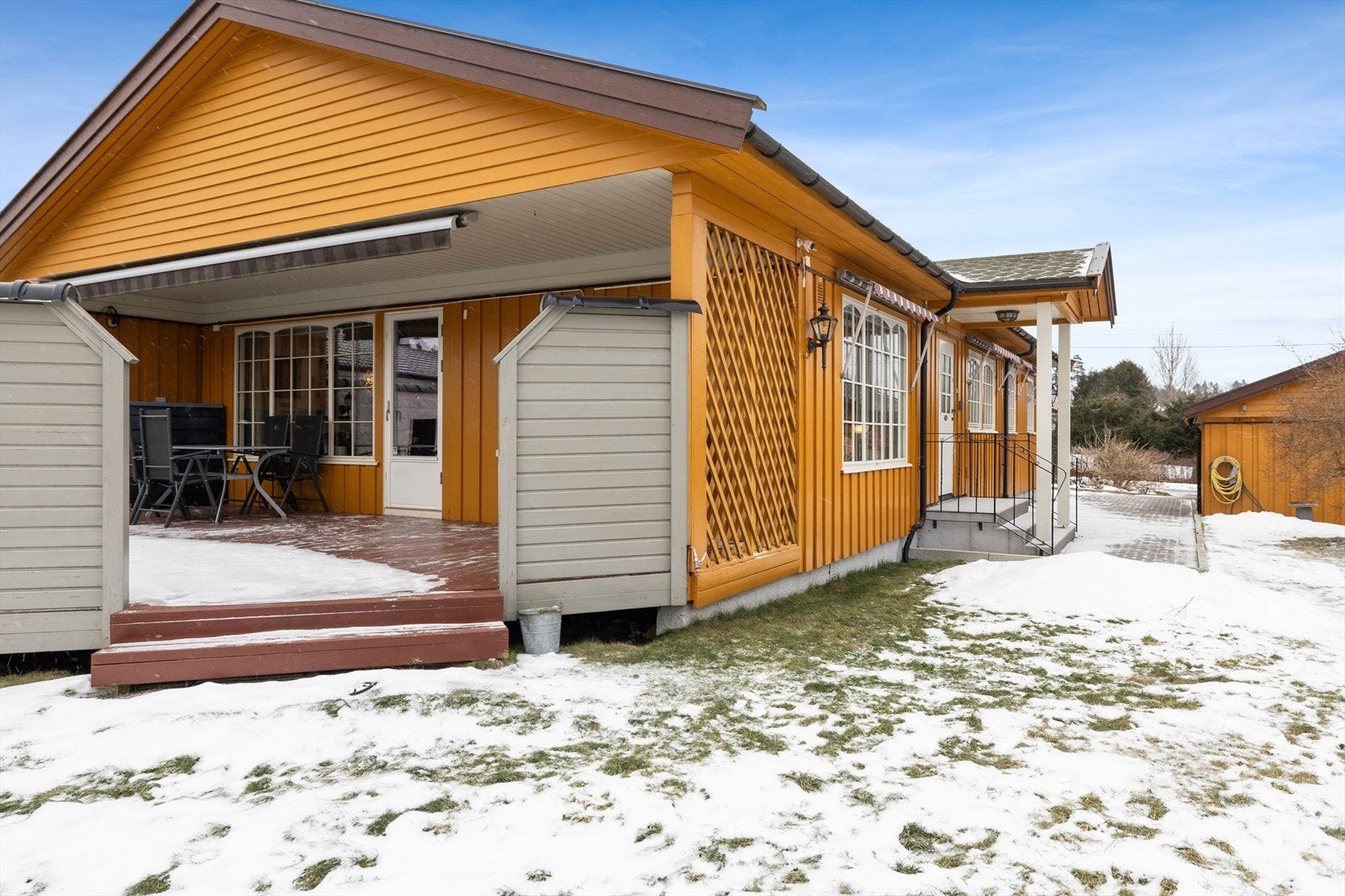 Koselig uteområde med trapp ned til hagen og fine oppholdsflater rundt huset. Galleribilde