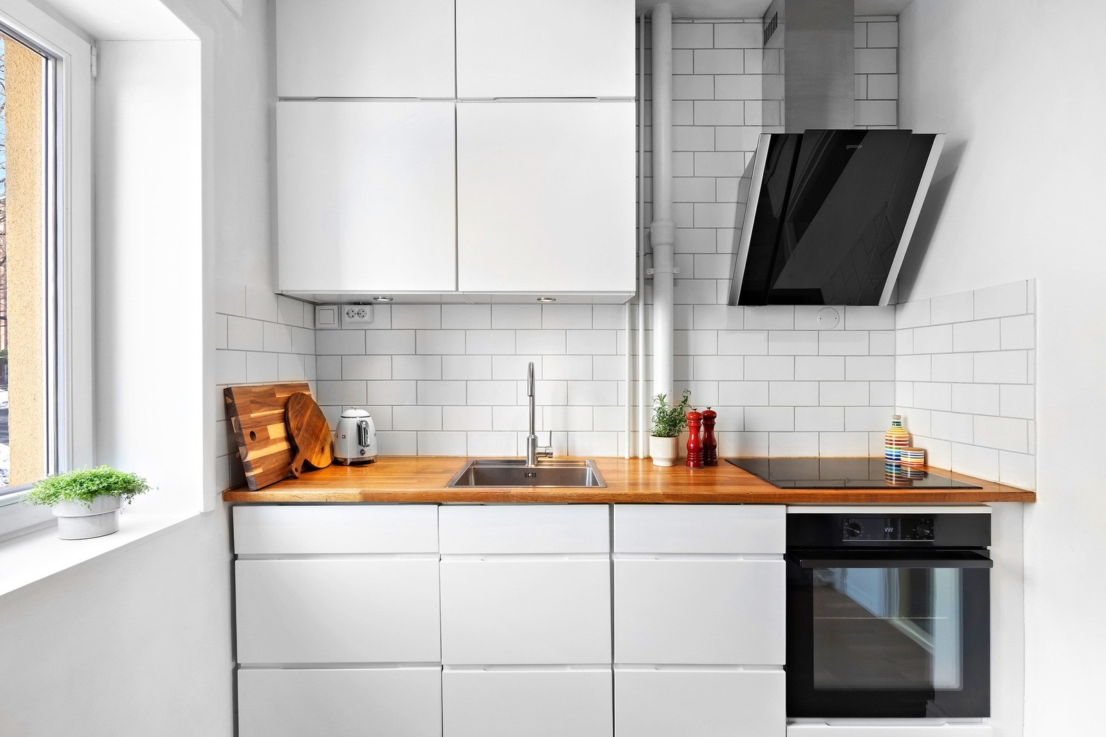 Kjøkkenet har heltre benkeplate og integrerte hvitevarer som oppvaskmaskin, stekeovn og platetopp. Galleribilde