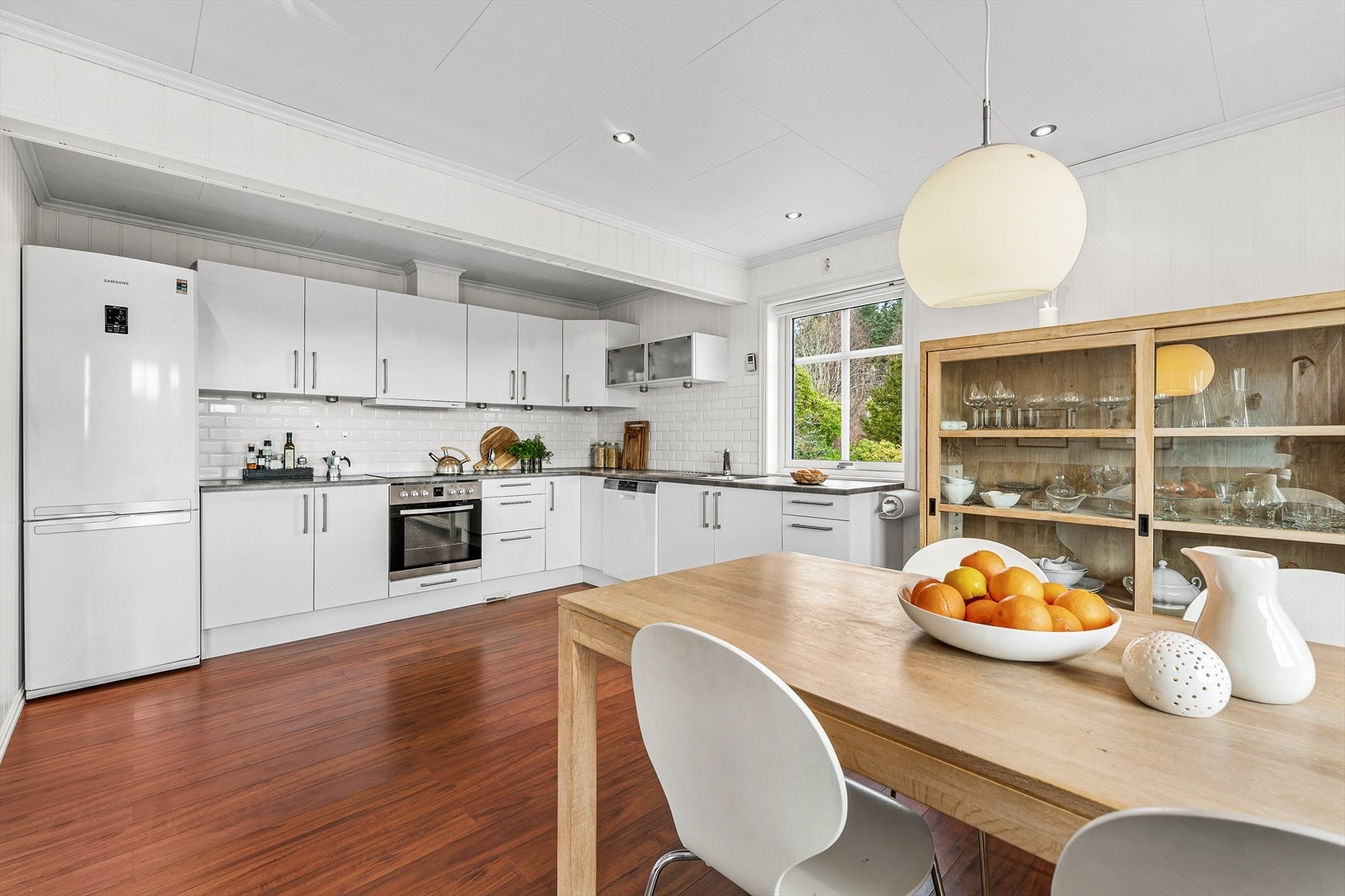 Hvitt, slett kjøkken med laminat benkeplate, og fliser over benkeplaten Galleribilde