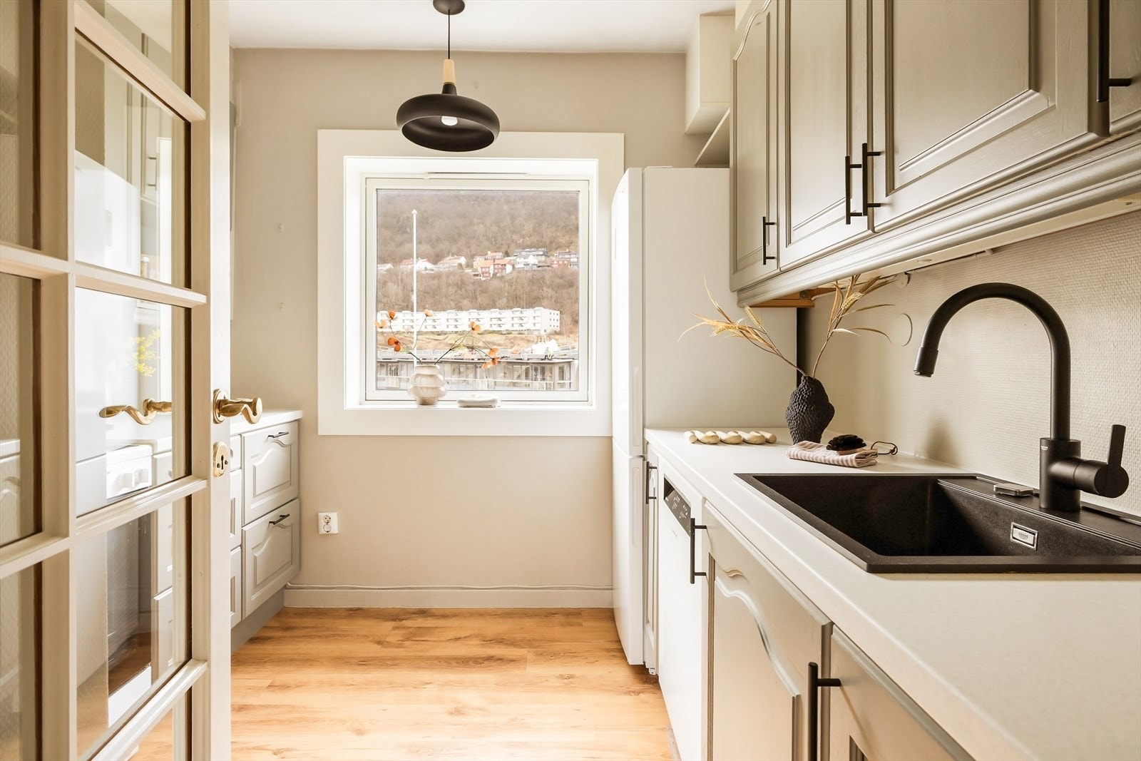 Kjøkkenet ligger i eget rom og gir en tydelig inndeling mellom oppholds- og arbeidsareal. Stort vindu gir godt arbeidslys og utsyn mens maten tilberedes. Galleribilde