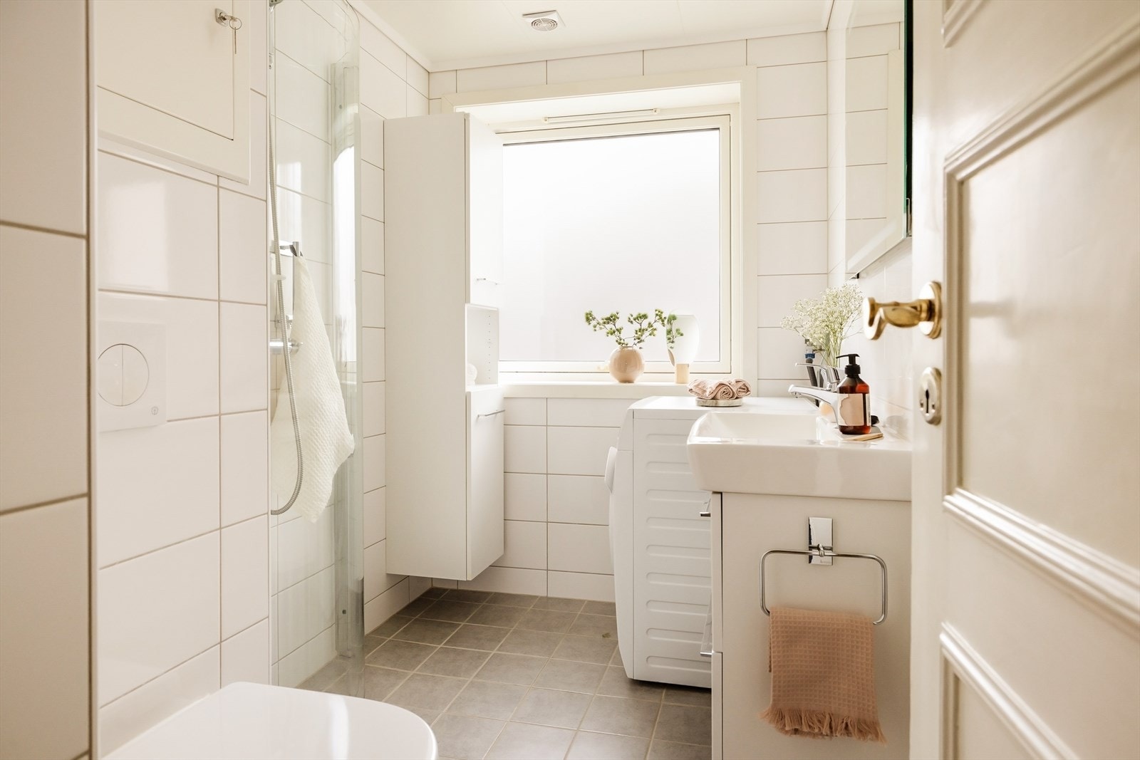 Flislagt bad med varmekabler, vegghengt toalett og dusj med takdusj og glassdør. Galleribilde