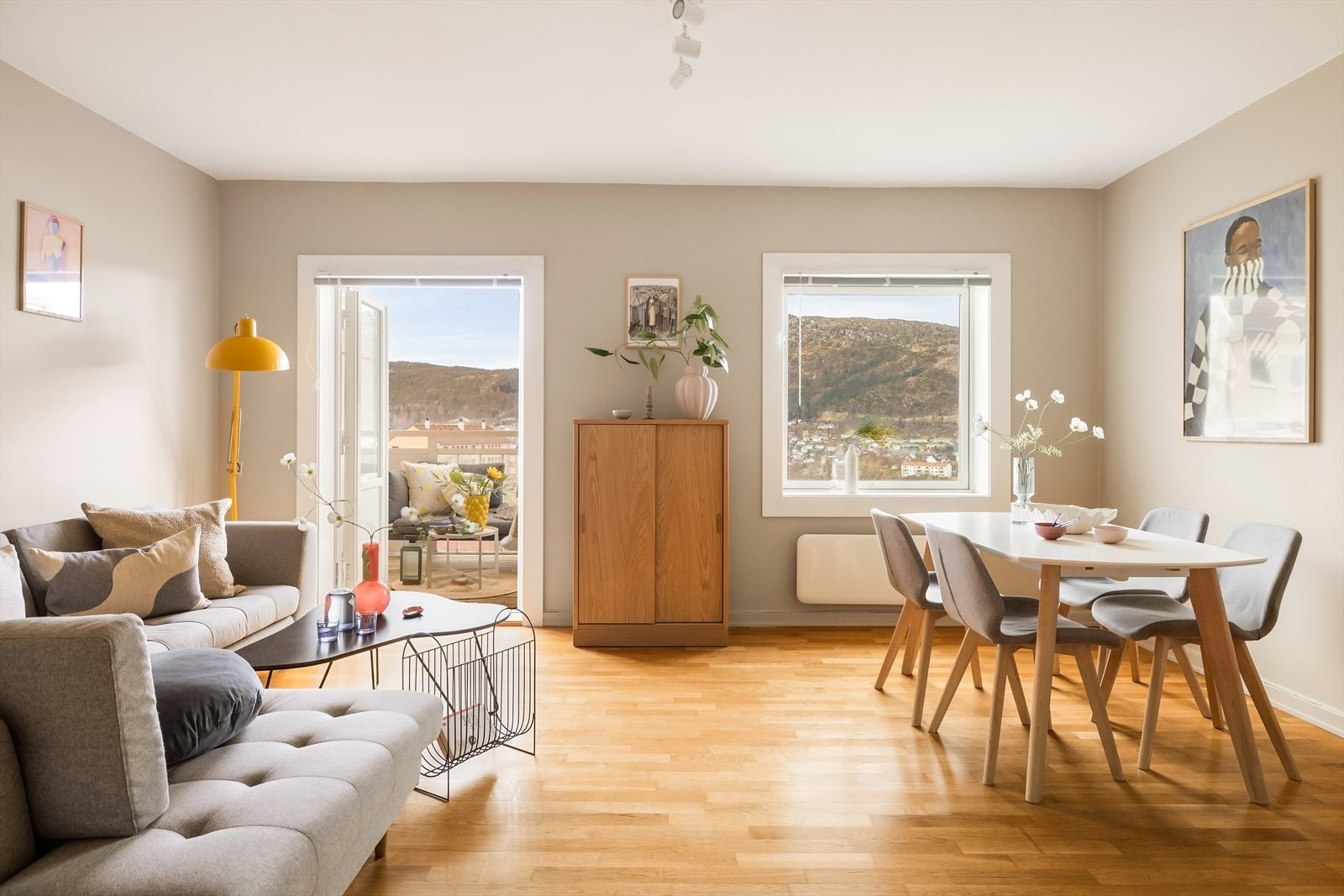 Den romslige stuen ligger i front av leiligheten og har et fantastisk lysinnslipp fra de store glassflatene. Med utsikt mot både naturen og byens liv, er dette et rom som både byr på ro og energi. Galleribilde