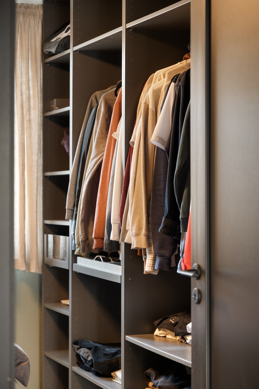 Effektiv oppbevaring med åpne garderobeløsninger langs veggen. Galleribilde