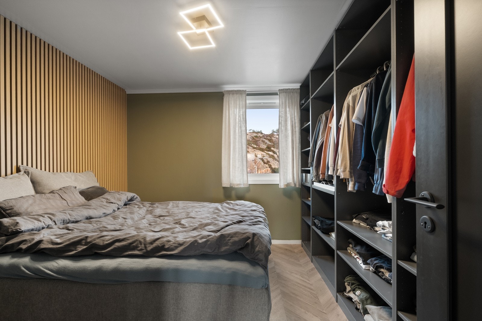 Spilevegger og laminatgulv gir et moderne preg i soverommet. Galleribilde