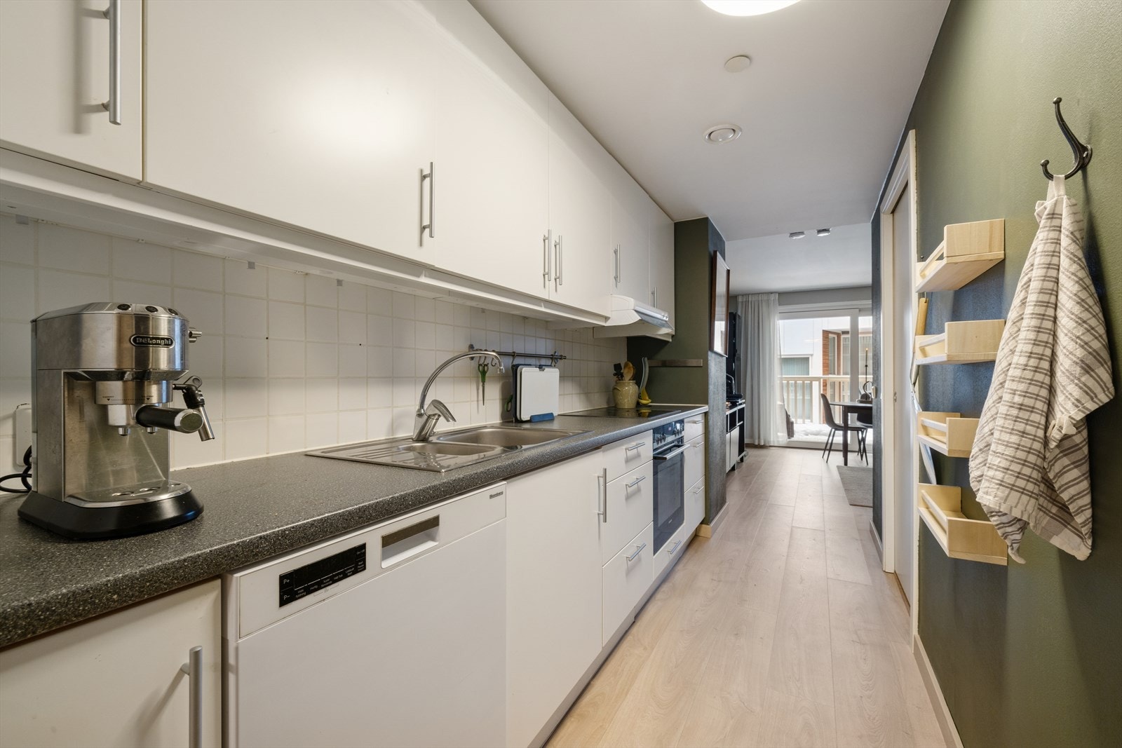 Kjøkkenet har moderne innredning med glatte fronter, laminert benkeplate og oppvaskkum i ståll. Galleribilde