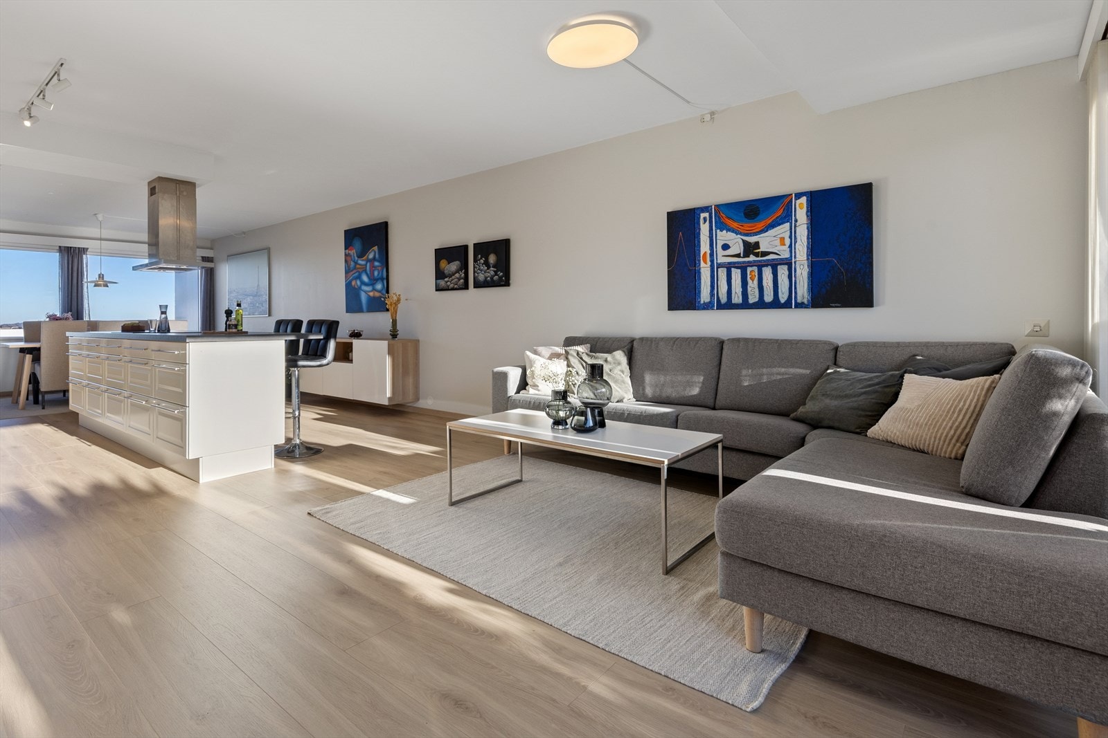 Lys og åpen stue med store vinduer på begge sider av leiligheten. Her får man bra med naturlig lys inn. Galleribilde