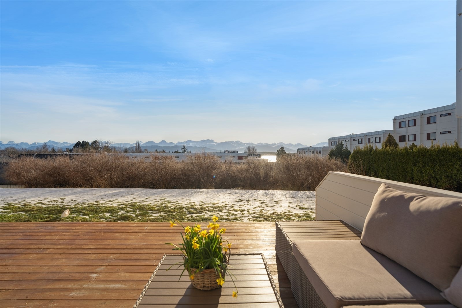 Terrassen har en myk og naturlig overgang til den felles plenen som omkranser borettslaget, noe som gir en åpen og innbydende følelse. Galleribilde