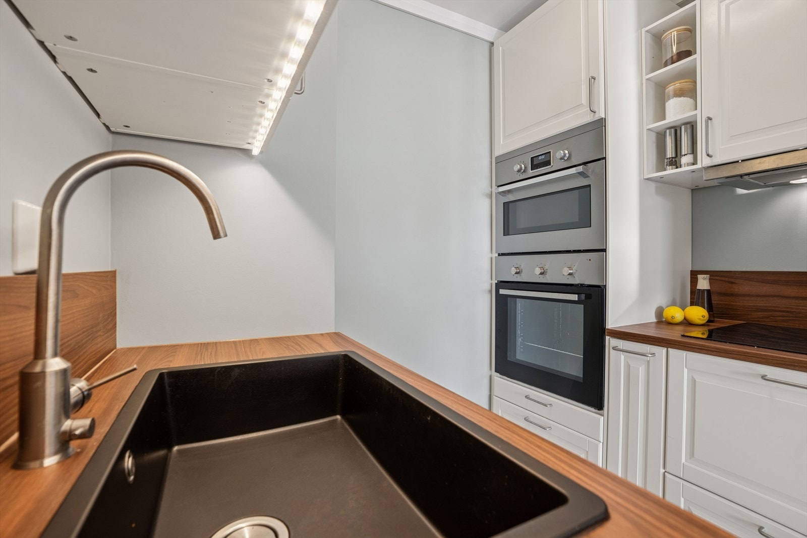 Kjøkkeninnredningen er fra IKEA med profilerte fronter og en laminert benkeplate som gir et tidløst og praktisk uttrykk. Over benkeflaten er det montert laminatplate som sprutsikring for enkel renhold. Galleribilde