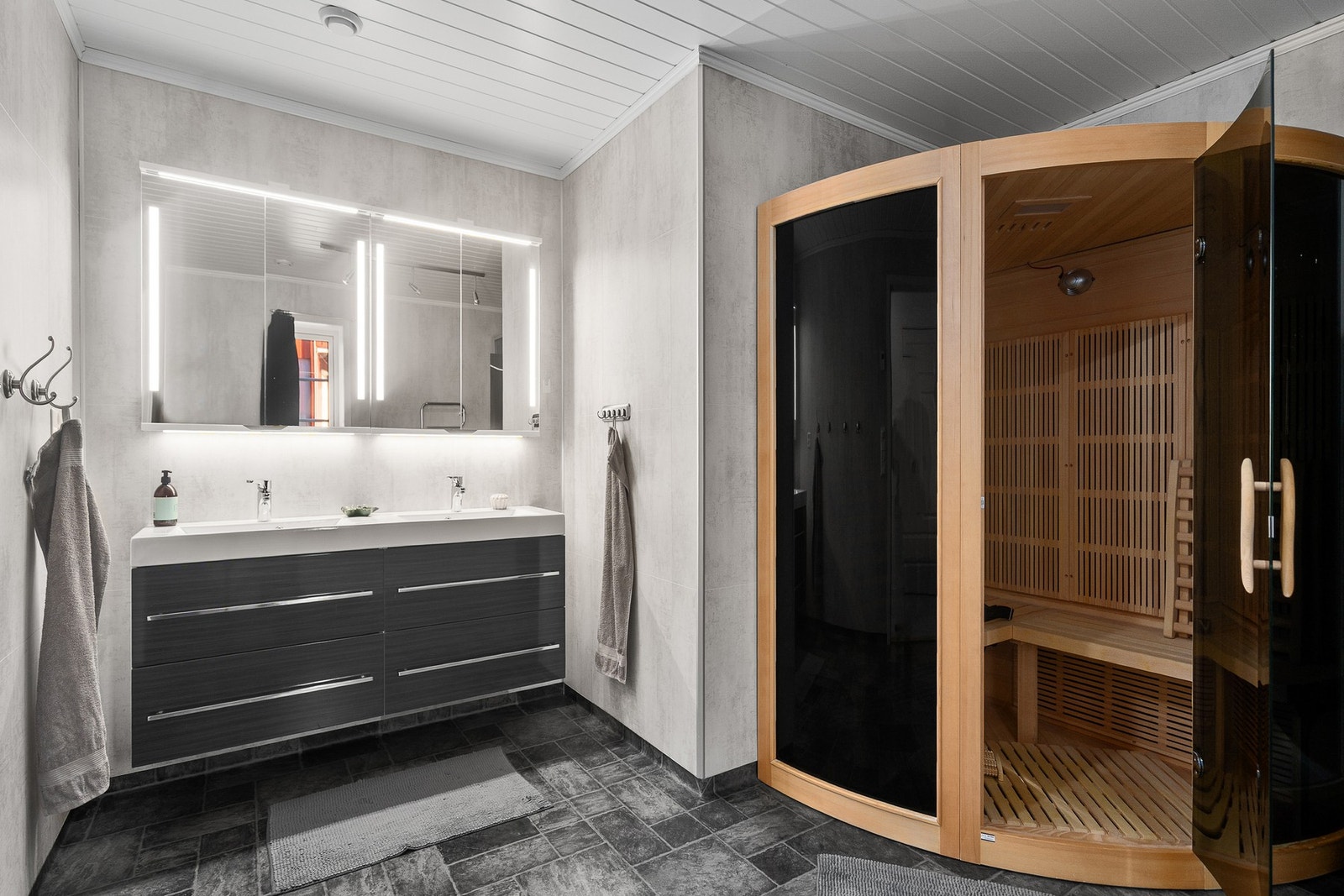 Stort bad med blant annet infrarød sauna, dusjkabinett, vegghengt wc og dobbelservant Galleribilde