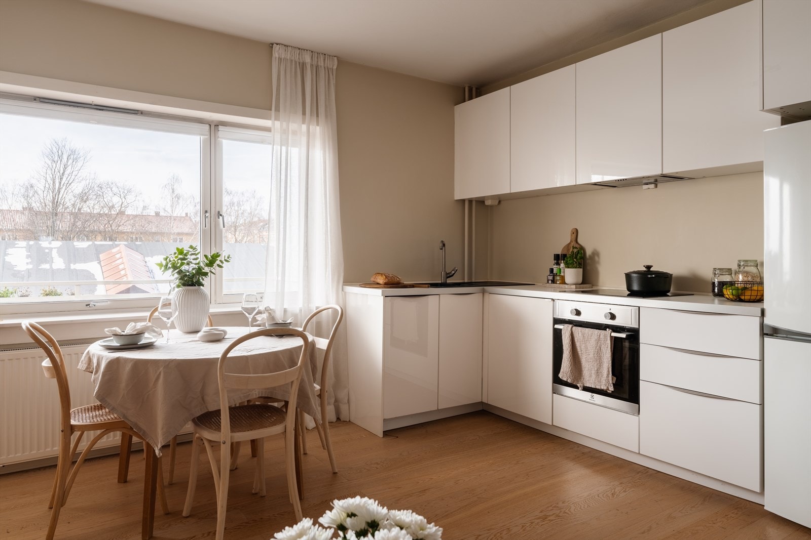 Kjøkkeninnredning fra 2014 med glatte, hvite fronter og benkeplate i laminat. Galleribilde