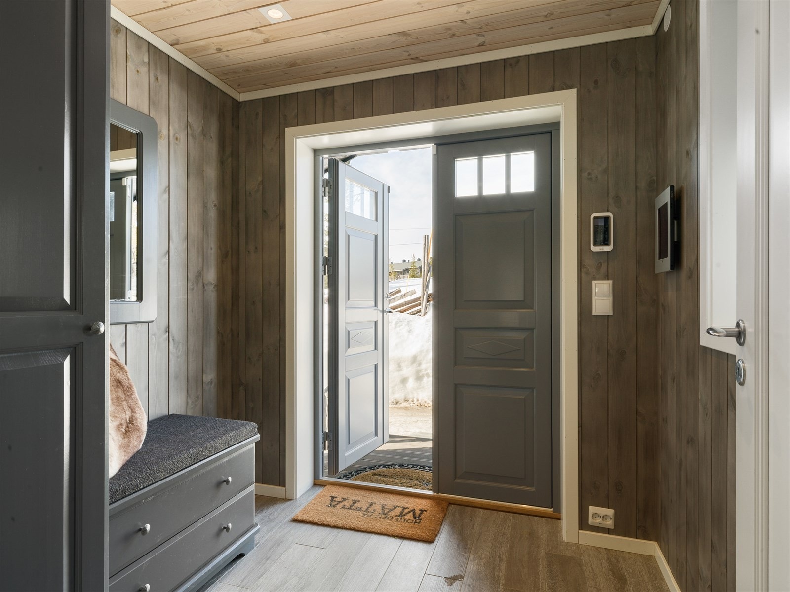 Eiendommen har en flott vindfang/entré med en praktisk tofløyet inngangsdør og her finner du varme- og lysstyringspanel. Velkommen inn! Galleribilde