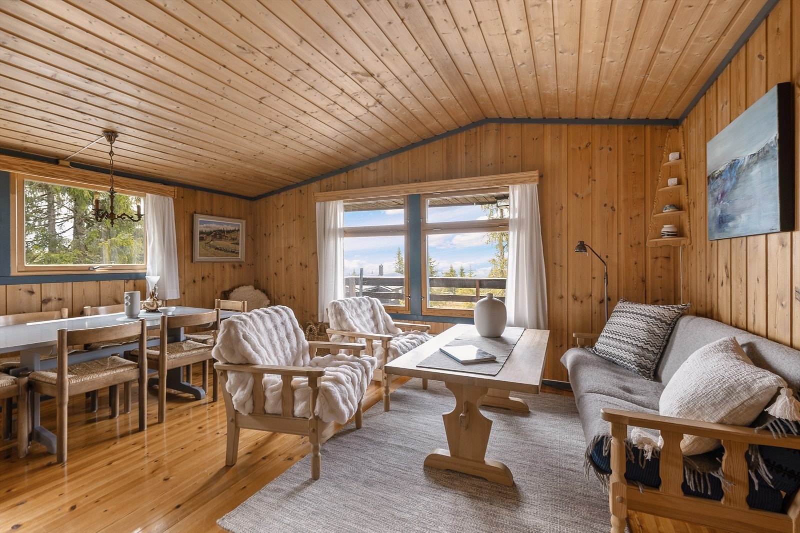 Det er et sosialt og hyggelig oppholdsrom i hytta med en åpen løsning mellom kjøkken og stue. Galleribilde