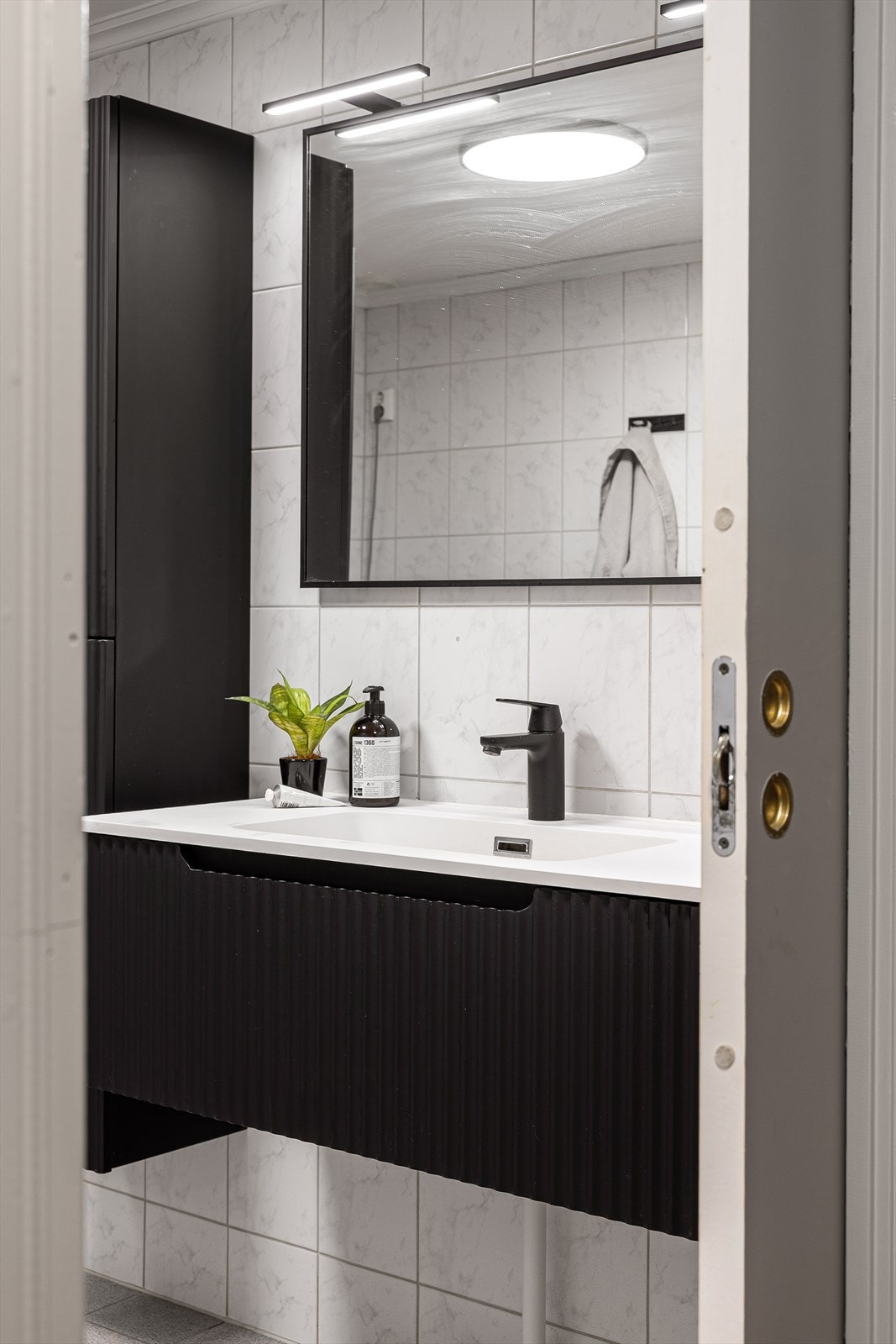 Oppgraderingen omfatter blant annet ny dusjløsning med stilrene glassvegger, samt ny servant med tilhørende innredning som gir både et pent uttrykk og praktisk oppbevaringsplass. Galleribilde