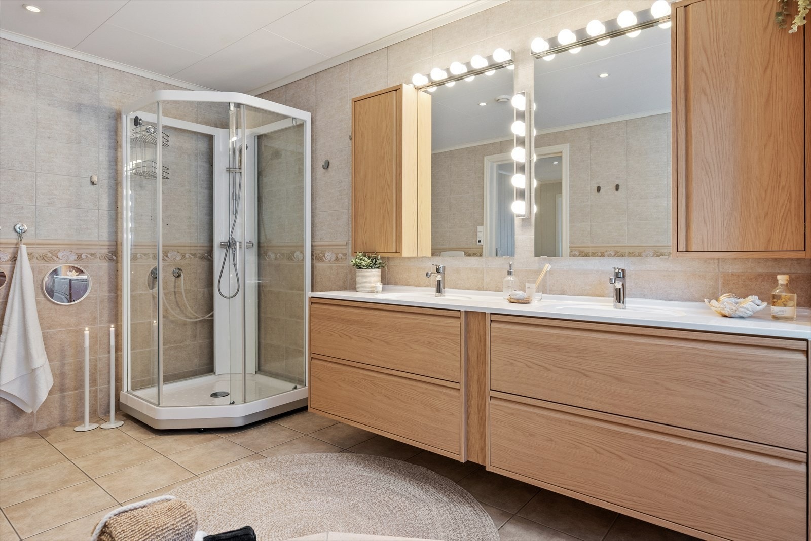 Varme er lagt i gulvet, og badet har både et dusjkabinett og et innfliset hjørnebadekar. Galleribilde