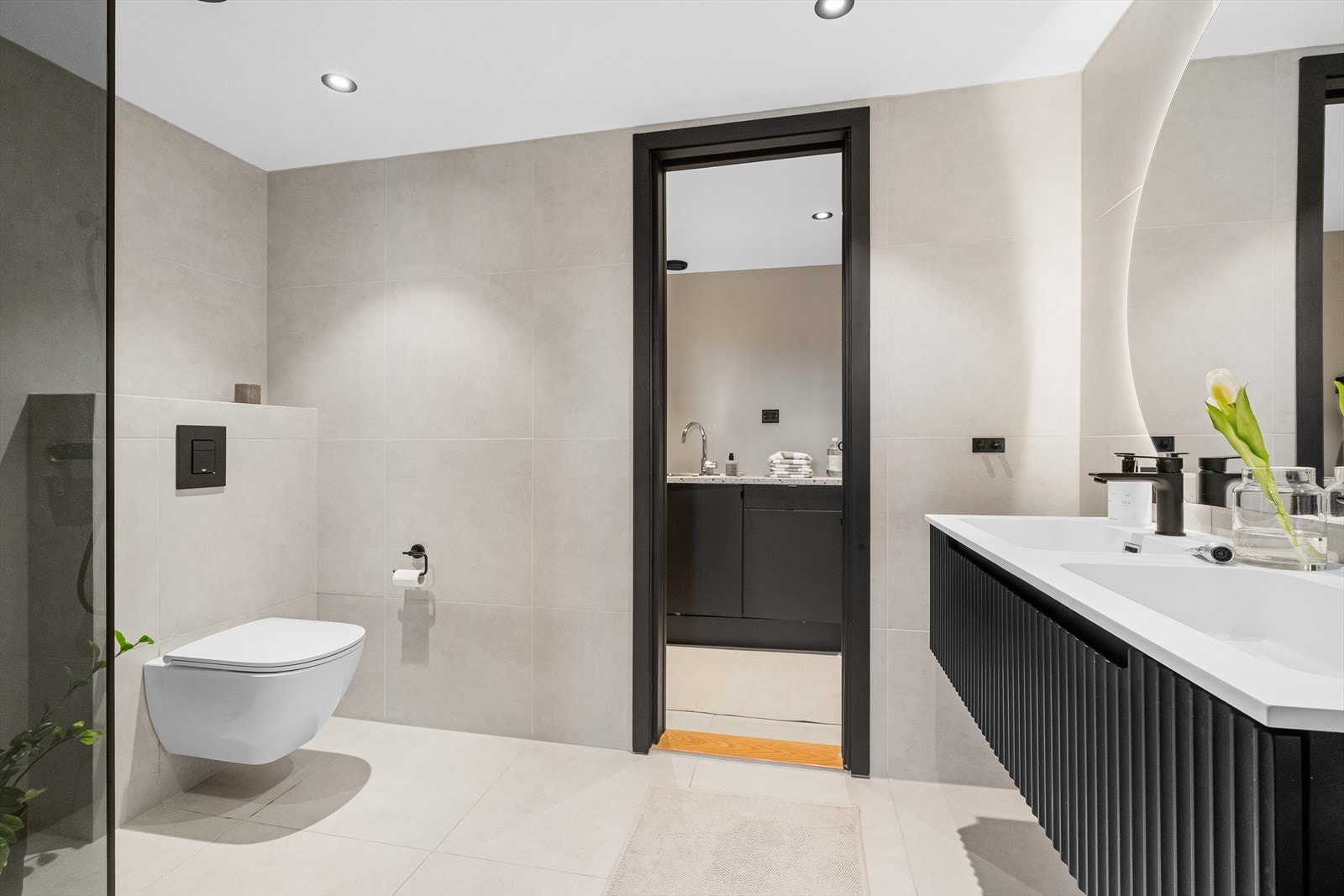 Badet ble, i likhet med resten av leiligheten, pusset opp i 2025. Her møtes du av store, lyse fliser og en moderne baderomsinnredning med svart blandebatteri og god oppbevaring. Galleribilde