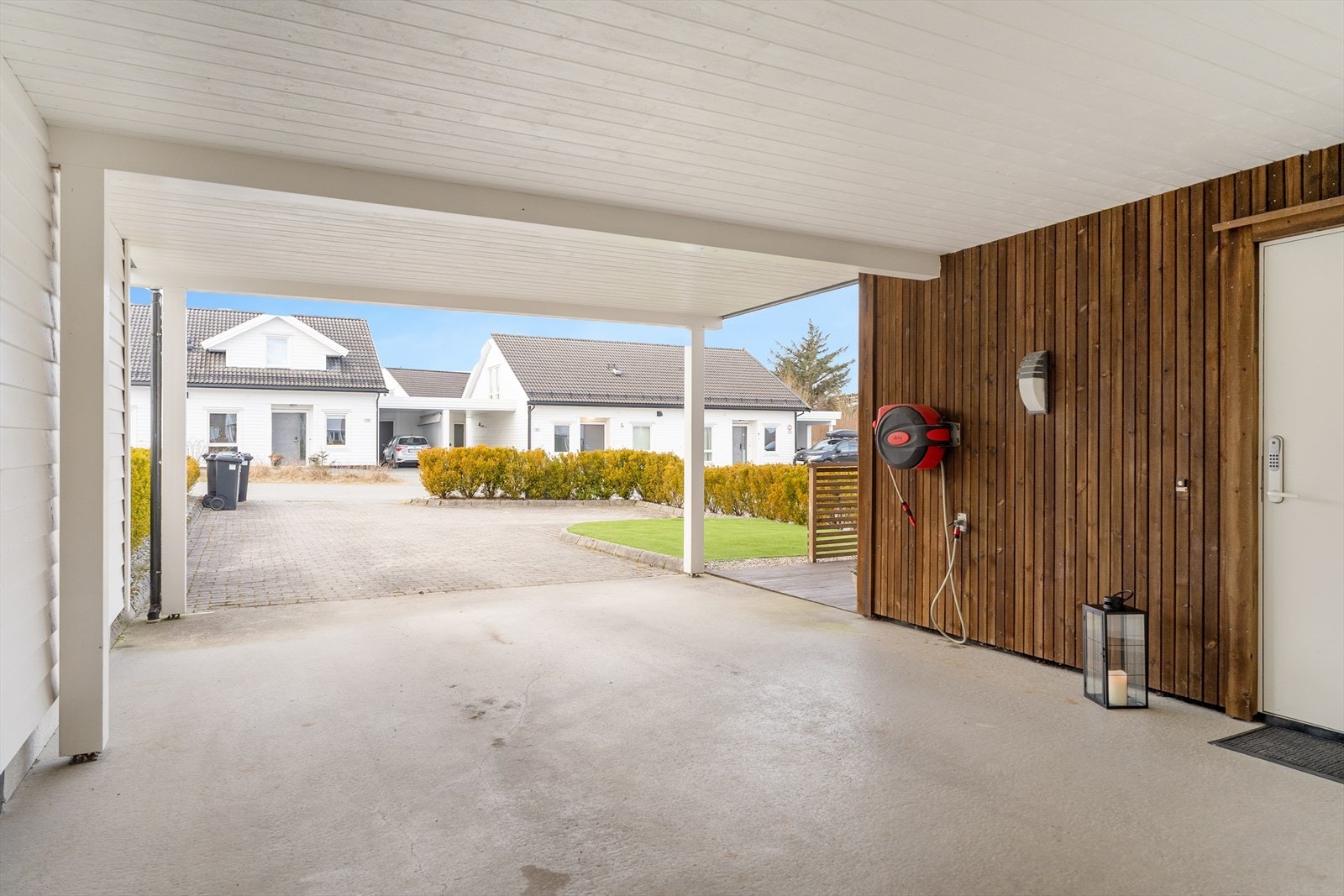 Gode parkeringsmuligheter i flott gårdsrom med belegningsstein og i egen carport Galleribilde