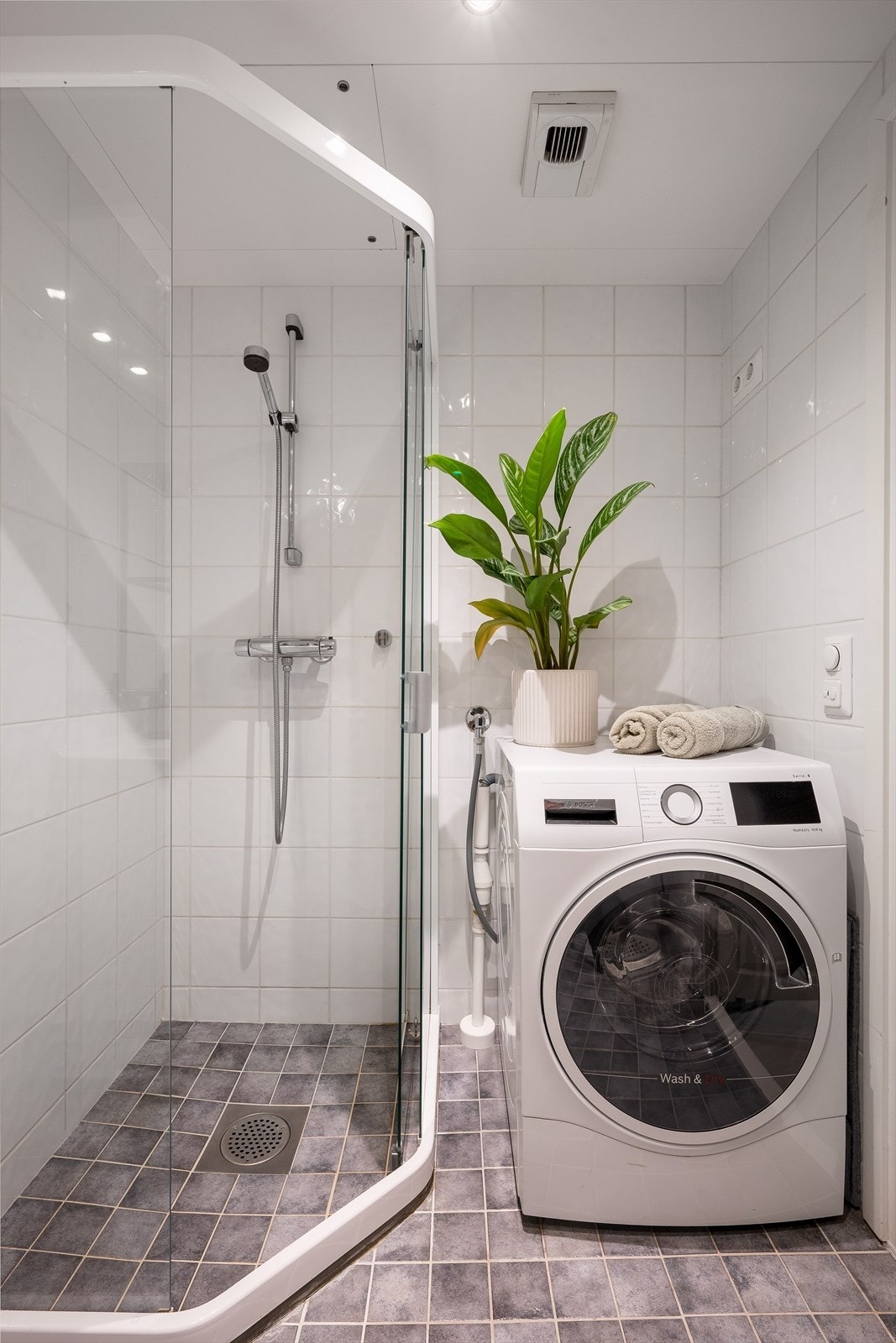 Badet er innredet med servant på servantskap, speil, toalett og dusjhjørne. Det er også opplegg for vaskemaskin i hjørnet. Galleribilde