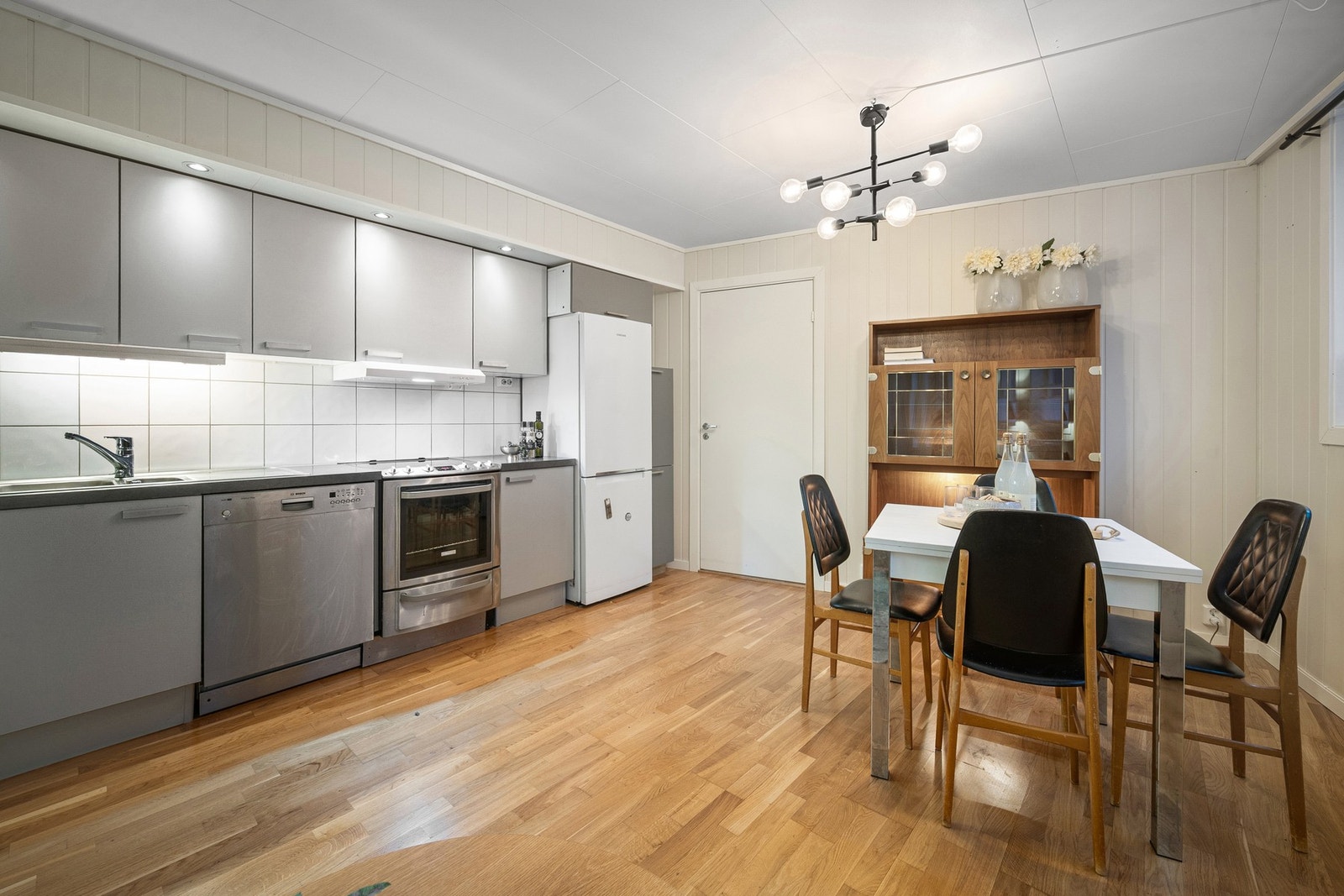 Kjøkkenet har stilren innredning med grå, slette fronter Galleribilde