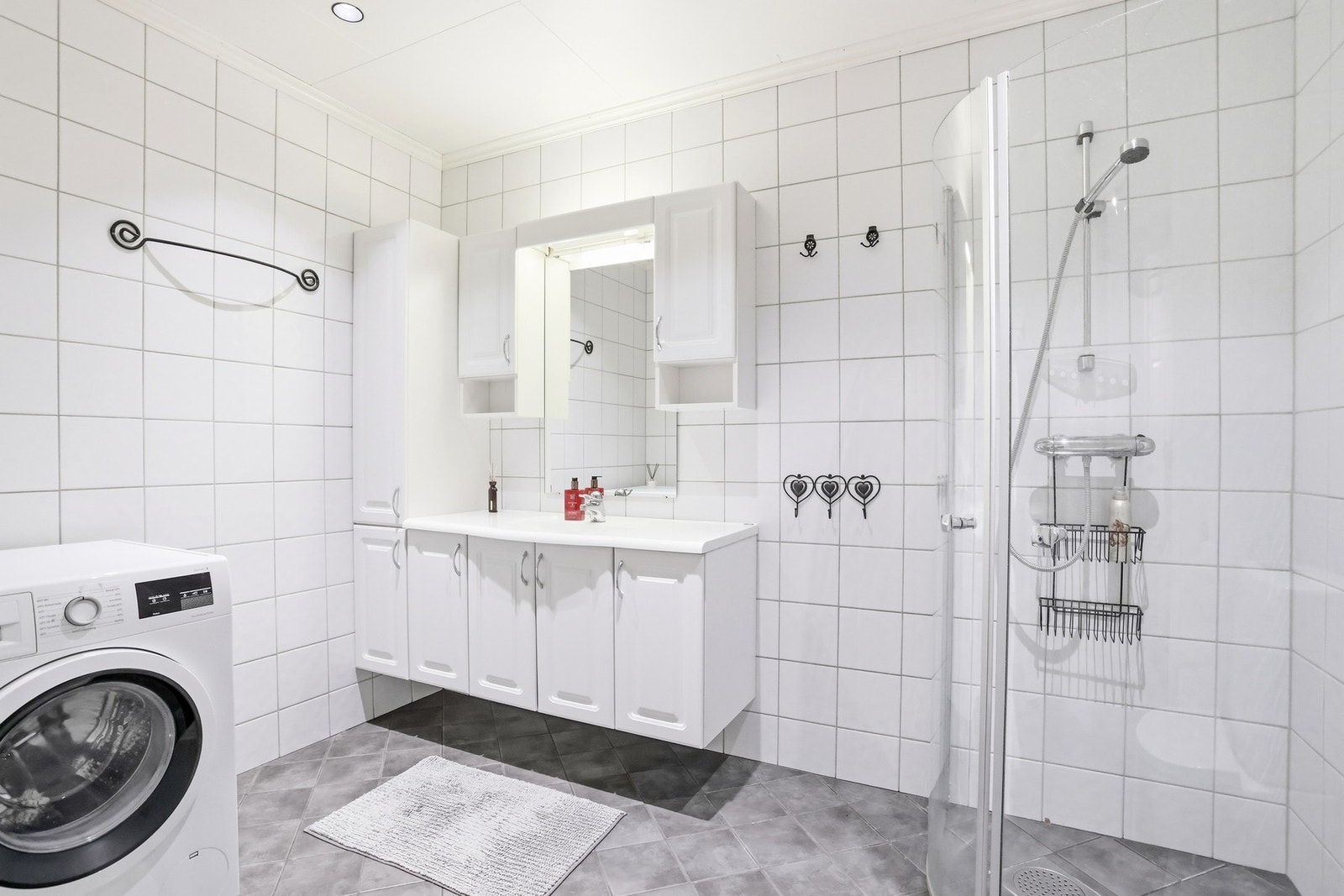 Pent bad som er innredet med toalett, dusjnisje med glassdører, baderomsinnredning med servant, samt opplegg for vaskemaskin. Galleribilde