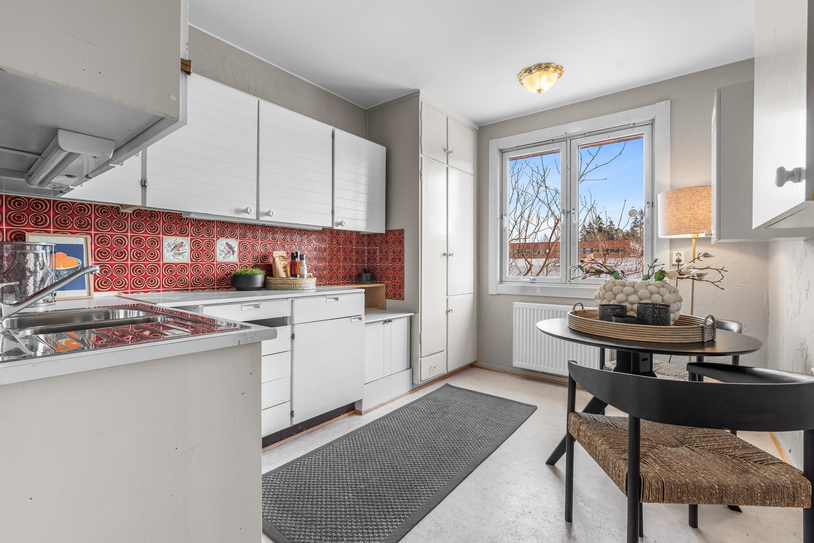 Fliser er montert på veggen over benkeplaten, og lysstoffrør under overskap gir praktisk belysning. Galleribilde