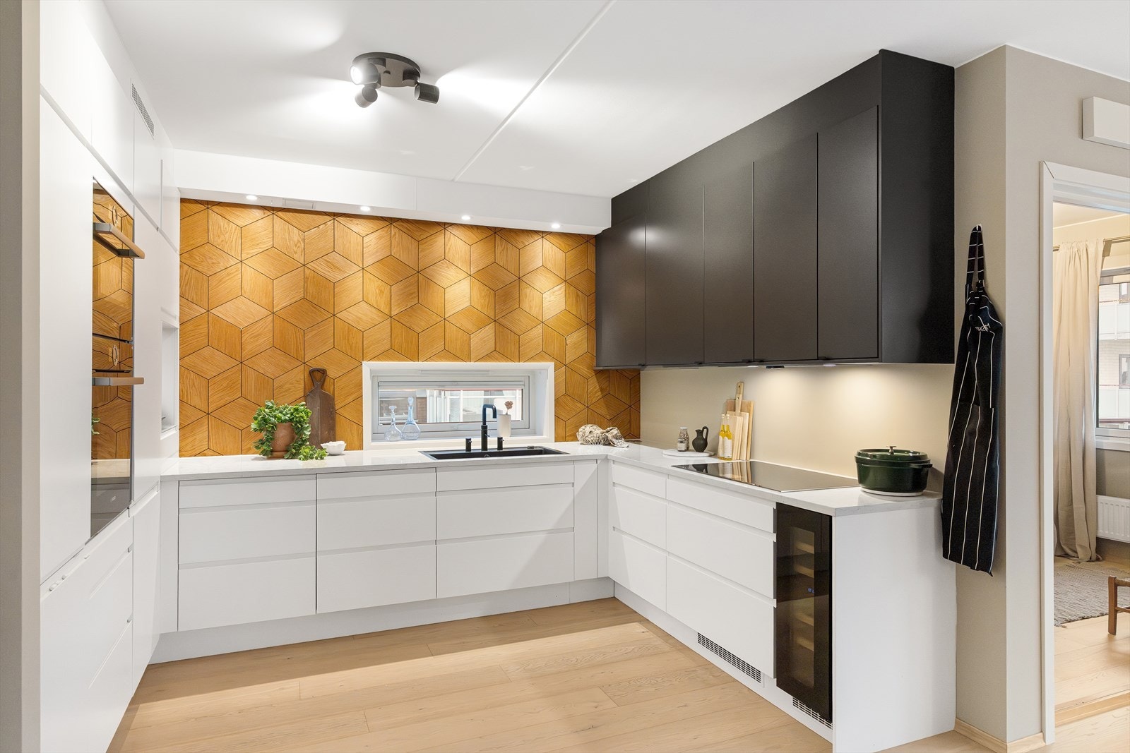 Kjøkkeninnredningen har slette fronter og en eksklusiv kompositt (kvarts) benkeplate med integrert oppvaskkum og ettgreps blandebatteri med Quooker-funksjon. Galleribilde