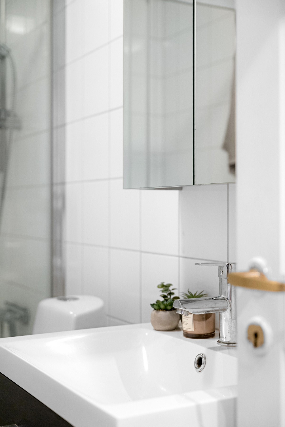 Moderne baderomsinnredning med ovenpåliggende servant, vegghengt speilskap over. Galleribilde