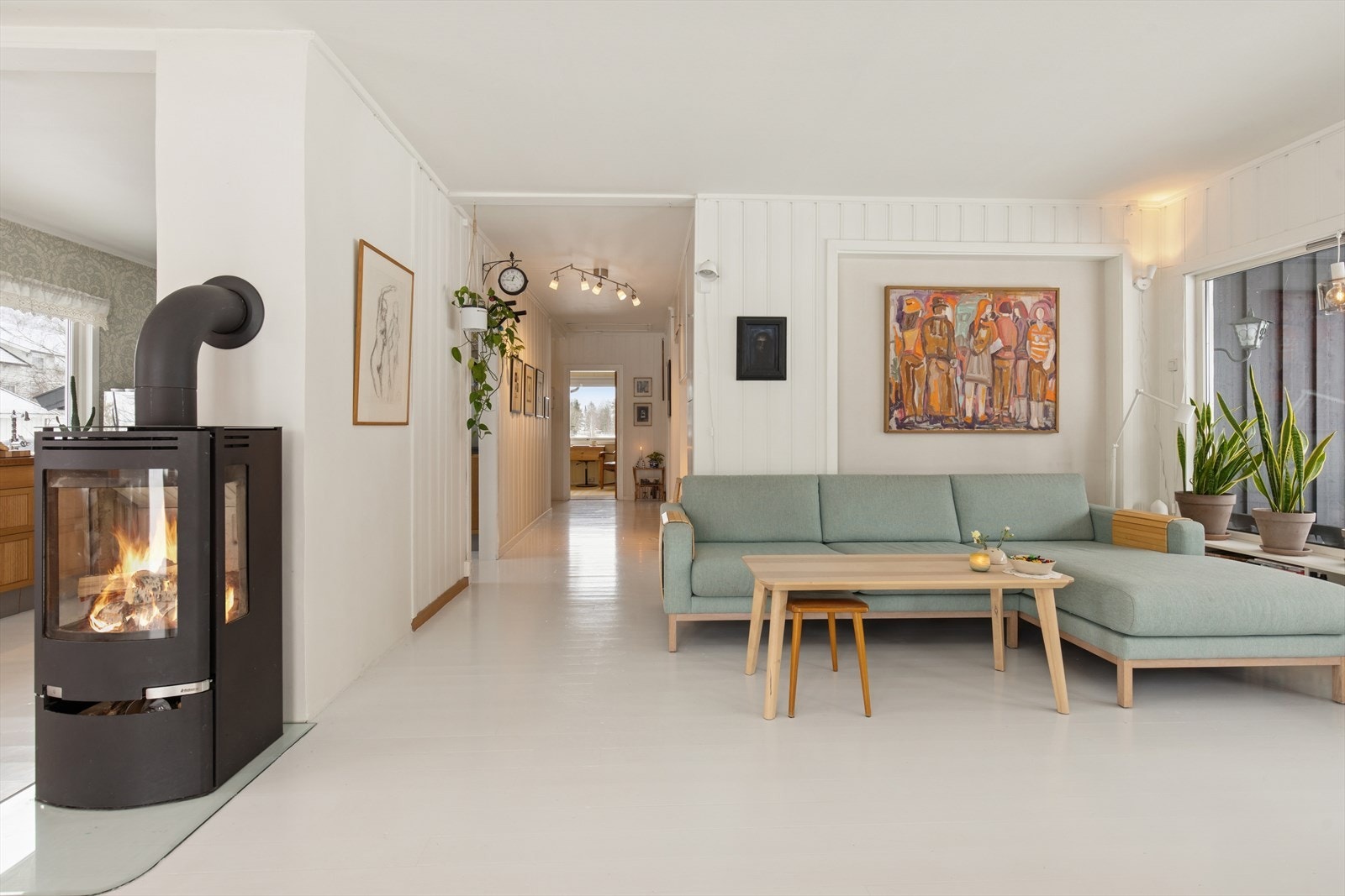 Romslig og lys stue med store vindusflater som slipper inn rikelig med dagslys og skaper en lun og harmonisk atmosfære. Galleribilde