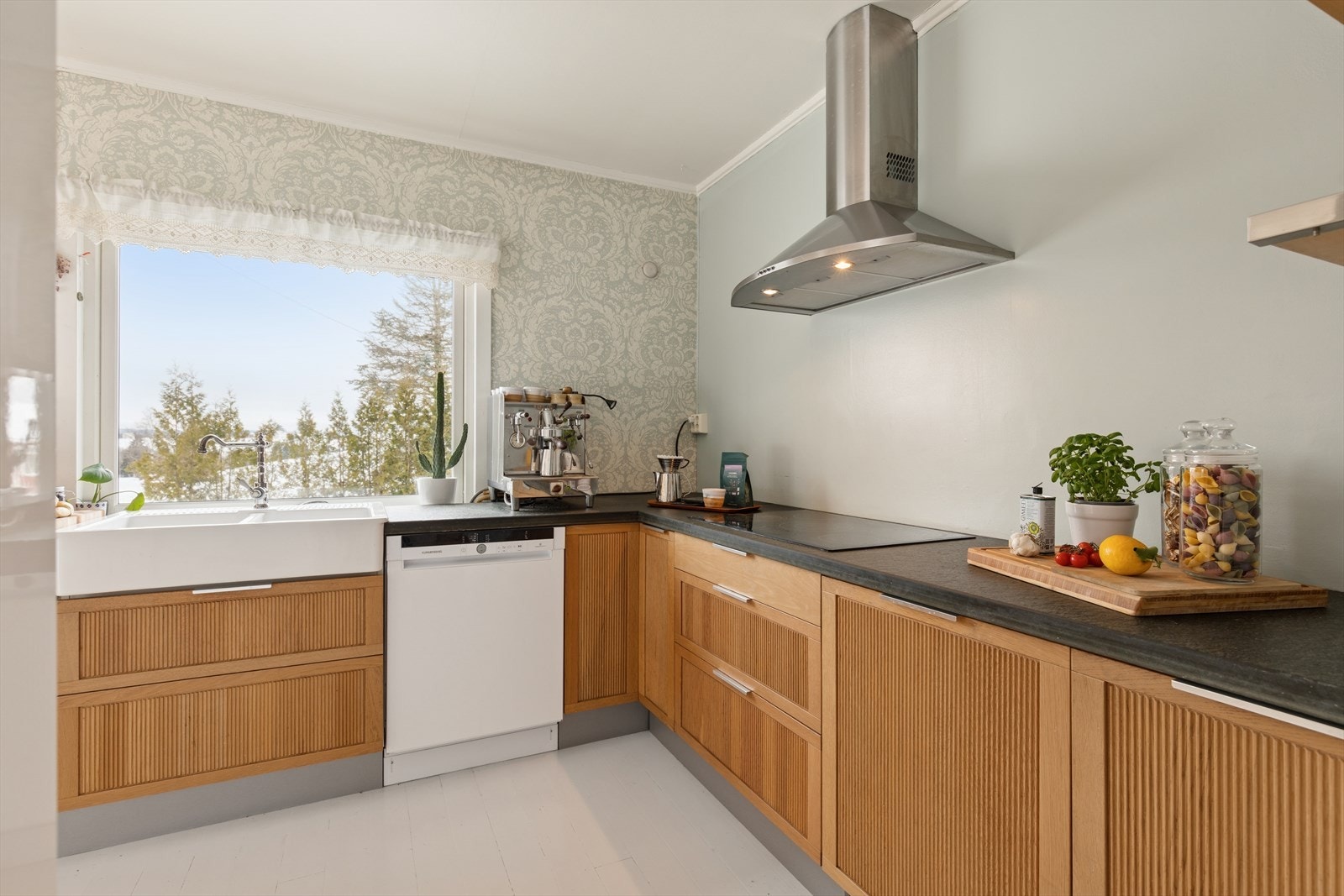 Benkeplater i heltre og skifer gir et solid og eksklusivt uttrykk. Nedfelt koketopp, stekeovn i høyskap og oppvaskmaskin i nisje. Galleribilde