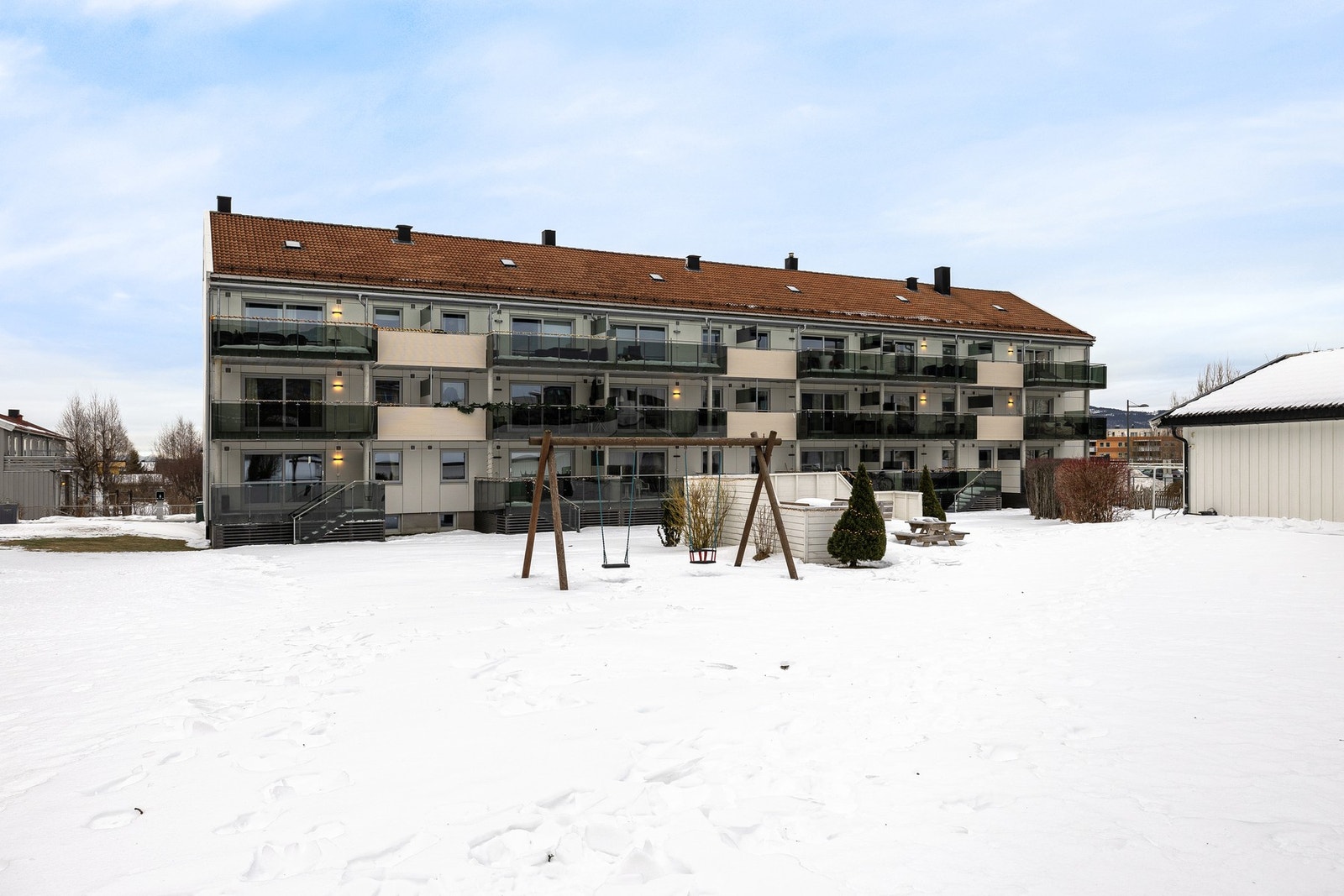 Borettslagets felles eiet tomt. Pent opparbeidet med plen og prydbusker. Galleribilde