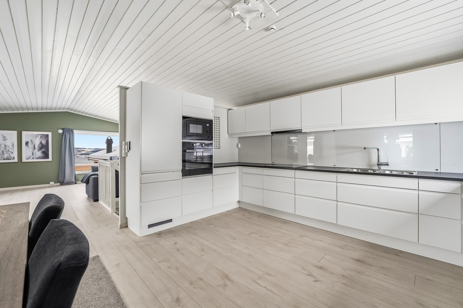 Stue med delvis åpen løsning fra kjøkken. Store vindusoverflater sørger for godt gjennomgående lys. Galleribilde