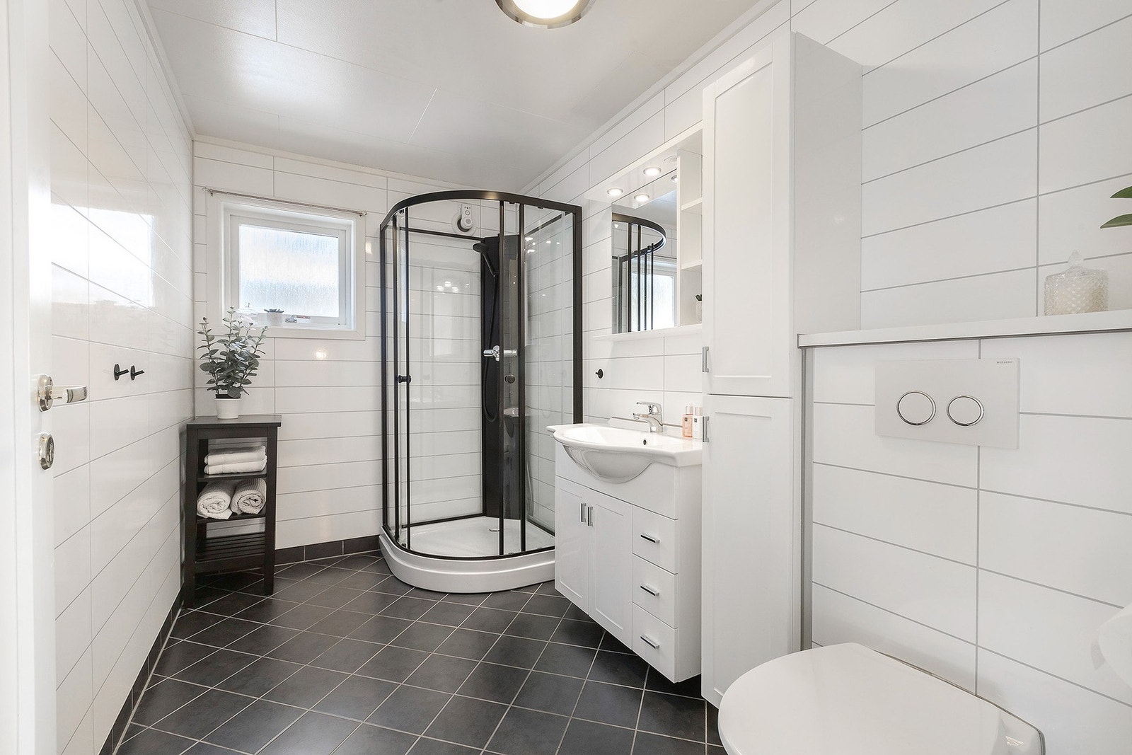 Bad i 1. etasje er fra 2012. Flislagt gulv med varme og baderomspanel på vegger. Galleribilde