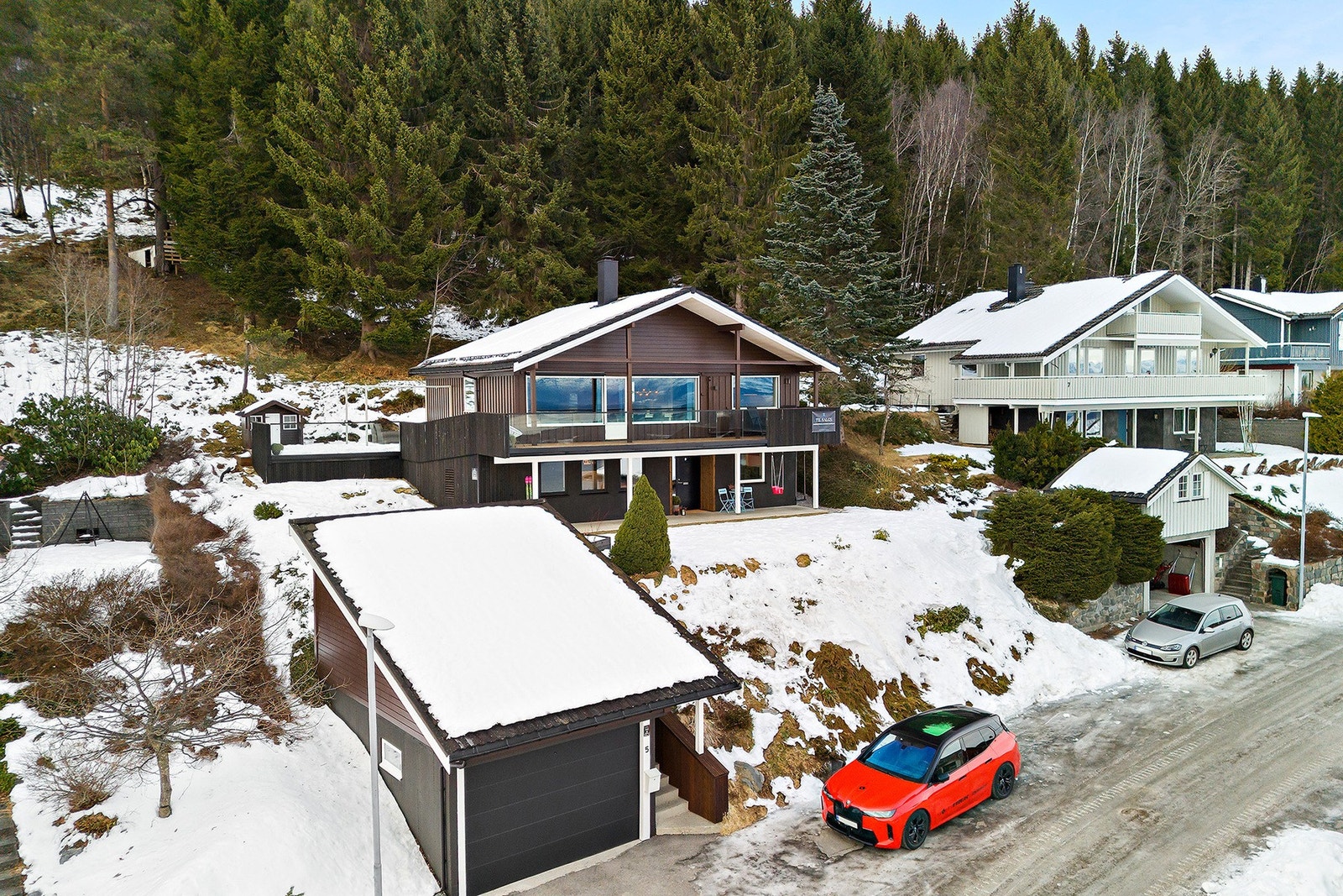 Støpt betongplatting med trapp ned mot garasje/vei. I områdene som ligger under åpen himmel, er det innstøpte varmekabler som sørger for snø og isfritt dekke vinterstid. Galleribilde