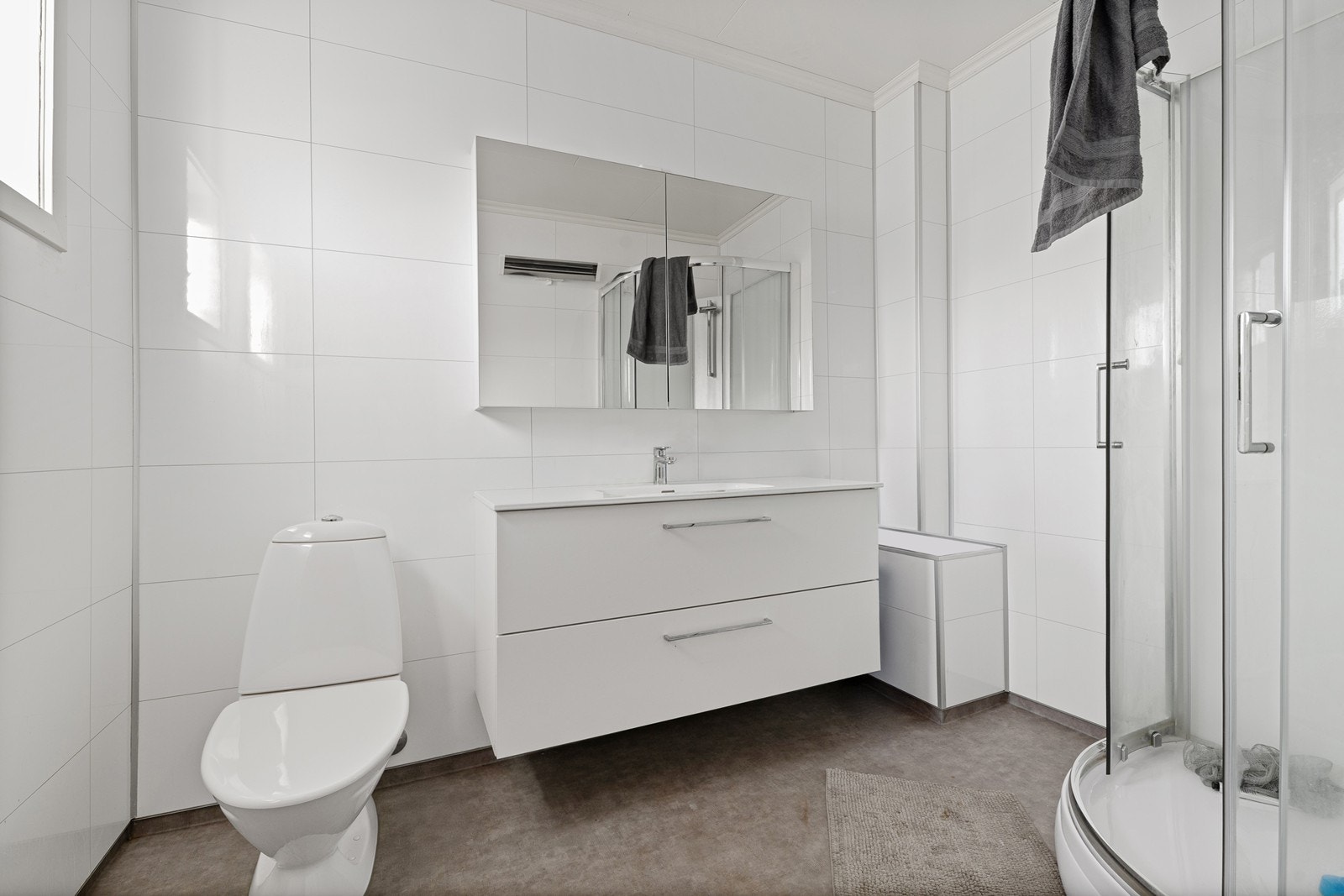 Badet i 2. etasje har baderomsplater på veggene og er utstyrt med innredning med nedfelt servant, toalett og dusjkabinett. Galleribilde