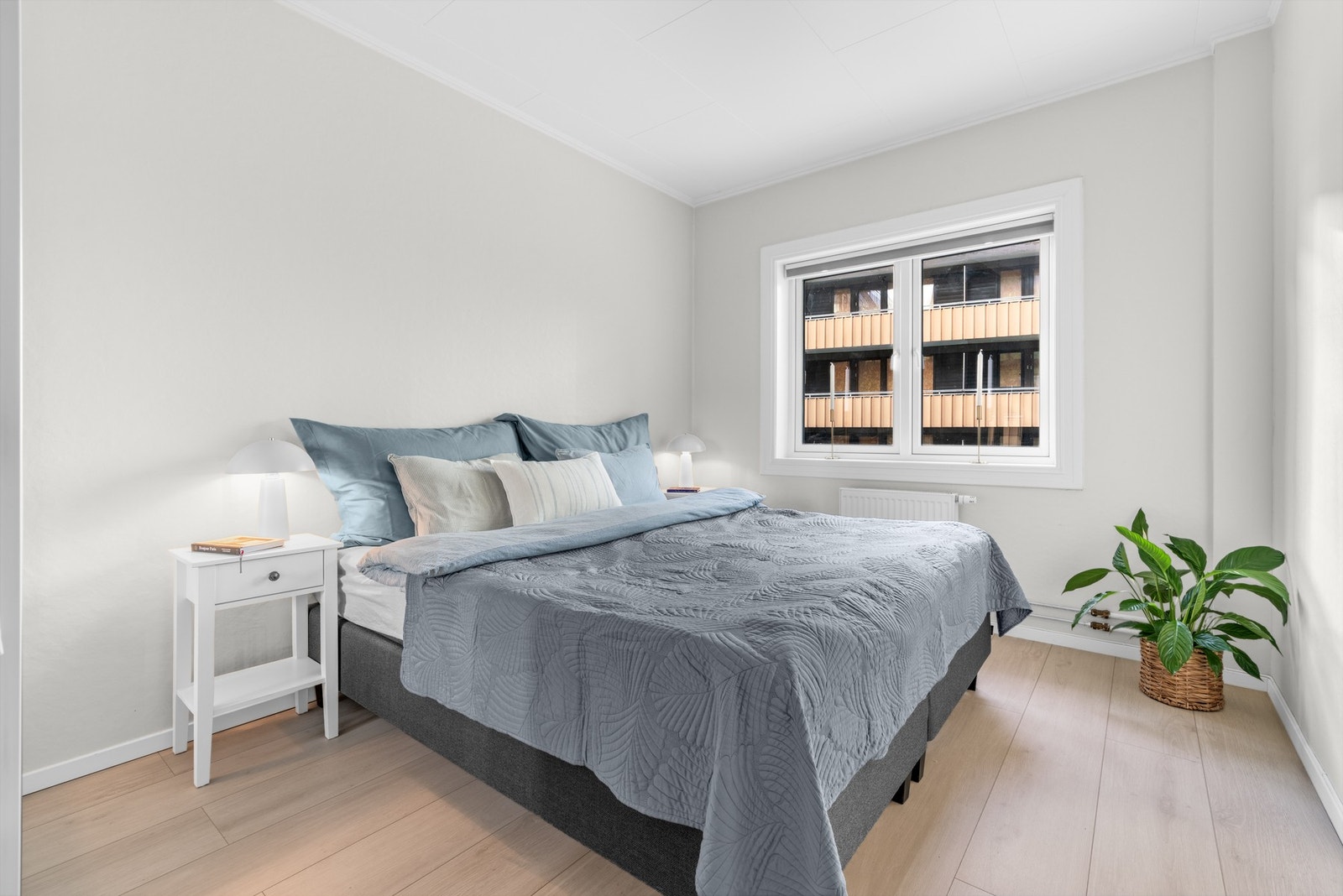 Leiligheten har et stort soverom med god plass dobbeltseng og tilhørende nattbord Galleribilde