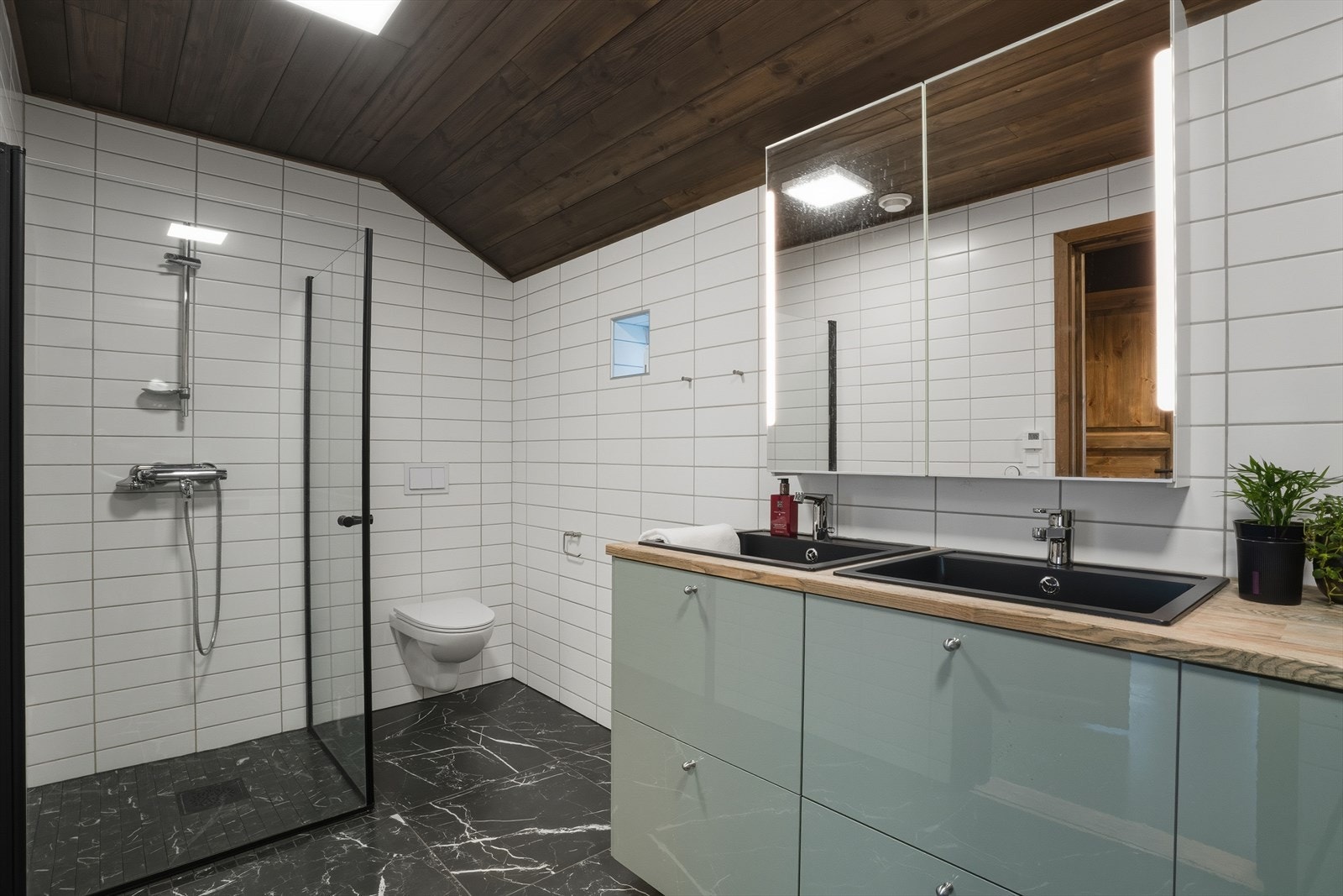 Flislagte vegger og gulv, panel i himling og vannbåren gulvvarme gir et lunt og eksklusivt inntrykk. Galleribilde