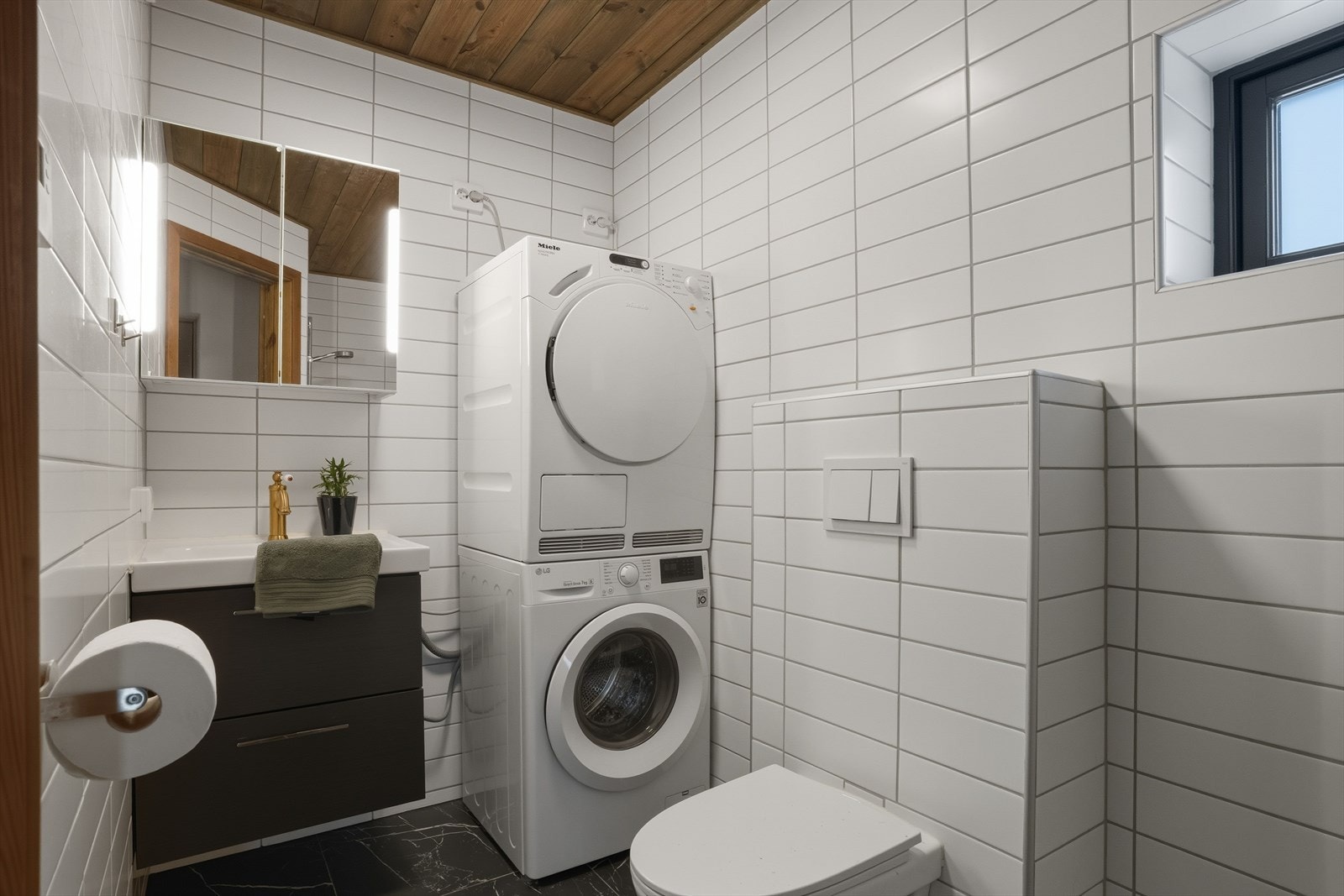 Hybelbadet er innredet med nedfelt servant, vegghengt toalett, dusjvegger/hjørne og opplegg for vaskemaskin og tørketrommel. Flislagte vegger og gulv, panel i taket og vannbåren gulvvarme gir en svært behagelig og moderne standard. Galleribilde