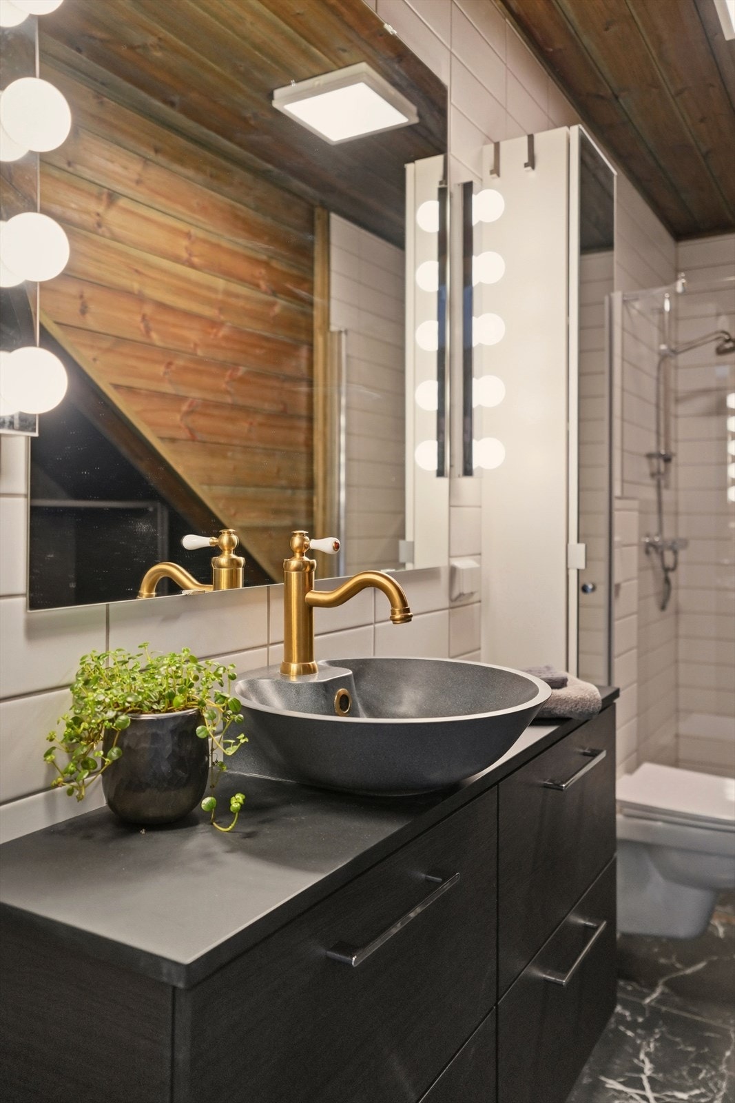 Kombinasjonen av fliser og panel med sokkelflis gir rommet en varm og moderne atmosfære. Panelet i taket og flislagt gulv med vannbåren varme gir god komfort året rundt. Galleribilde