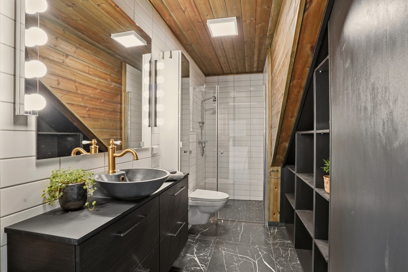 Pent bad med innredning med nedfelt servant, vegghengt toalett og dusjhjørne. Galleribilde