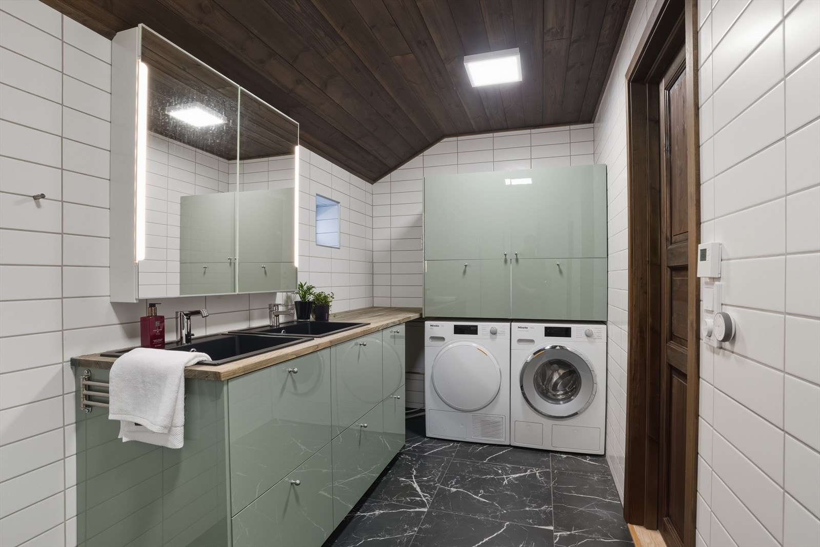 Romslig og stilrent bad med moderne innredning med doble, nedfelte servanter, veggmontert toalett, dusjhjørne med glassvegger. Galleribilde