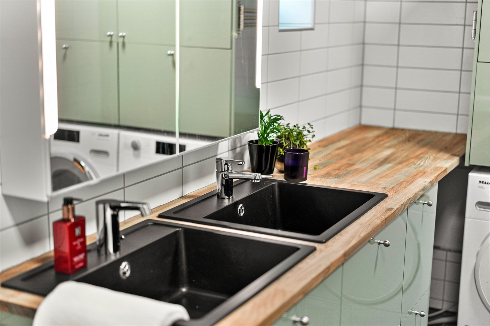 Badet har også praktisk opplegg for vaskemaskin, samt masse god oppbevaring i skaper under servantene, samt skap over vaskemaskin og tørketrommel Galleribilde